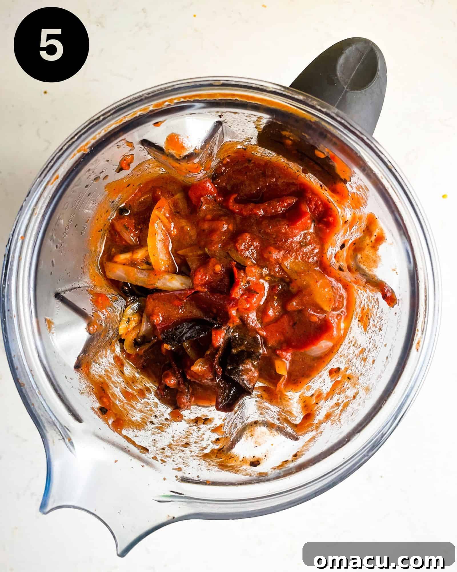 birria consume ingredients in a blender, forming a smooth paste.