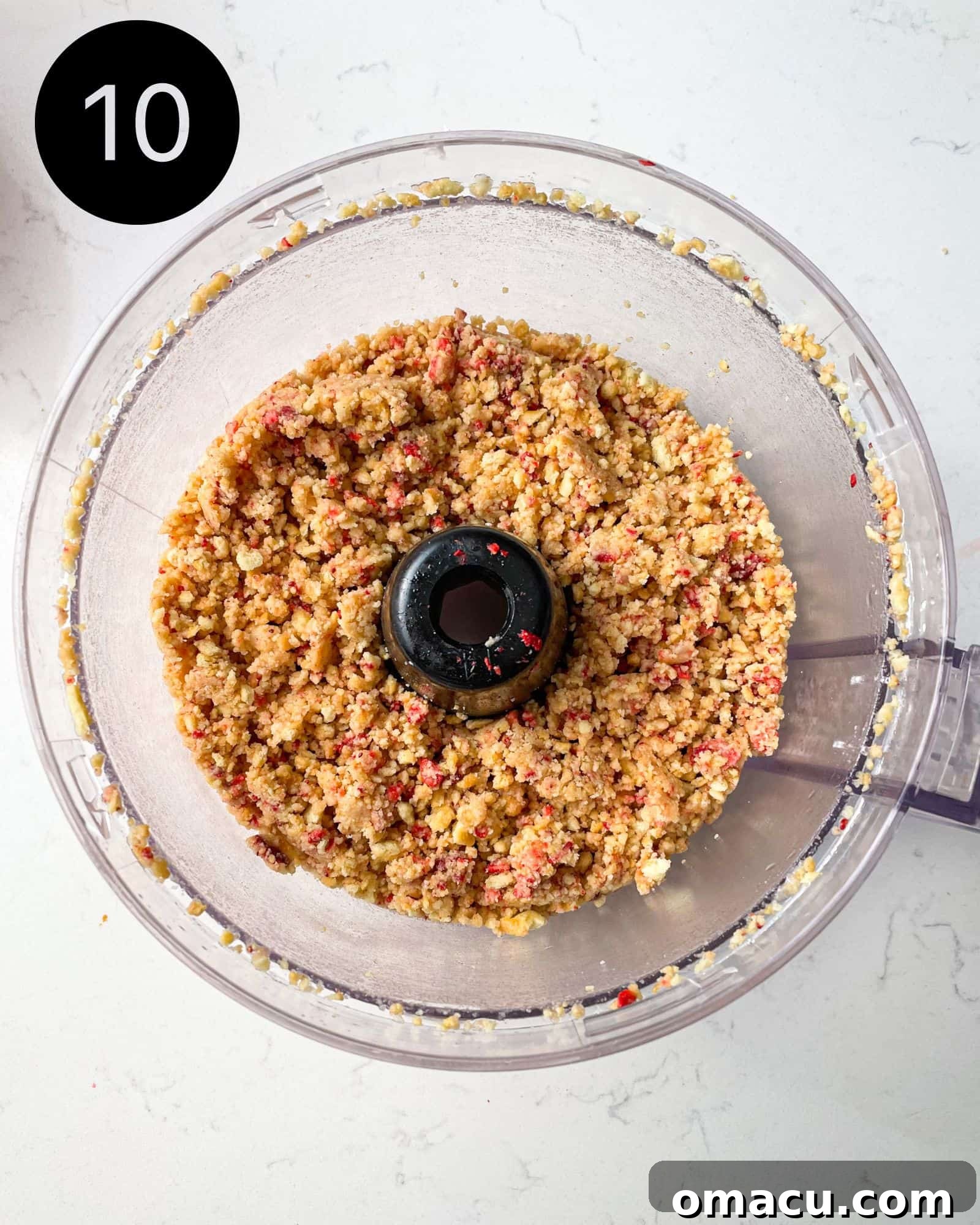 strawberry shortcake crumbles being processed in a food processor until chunky.