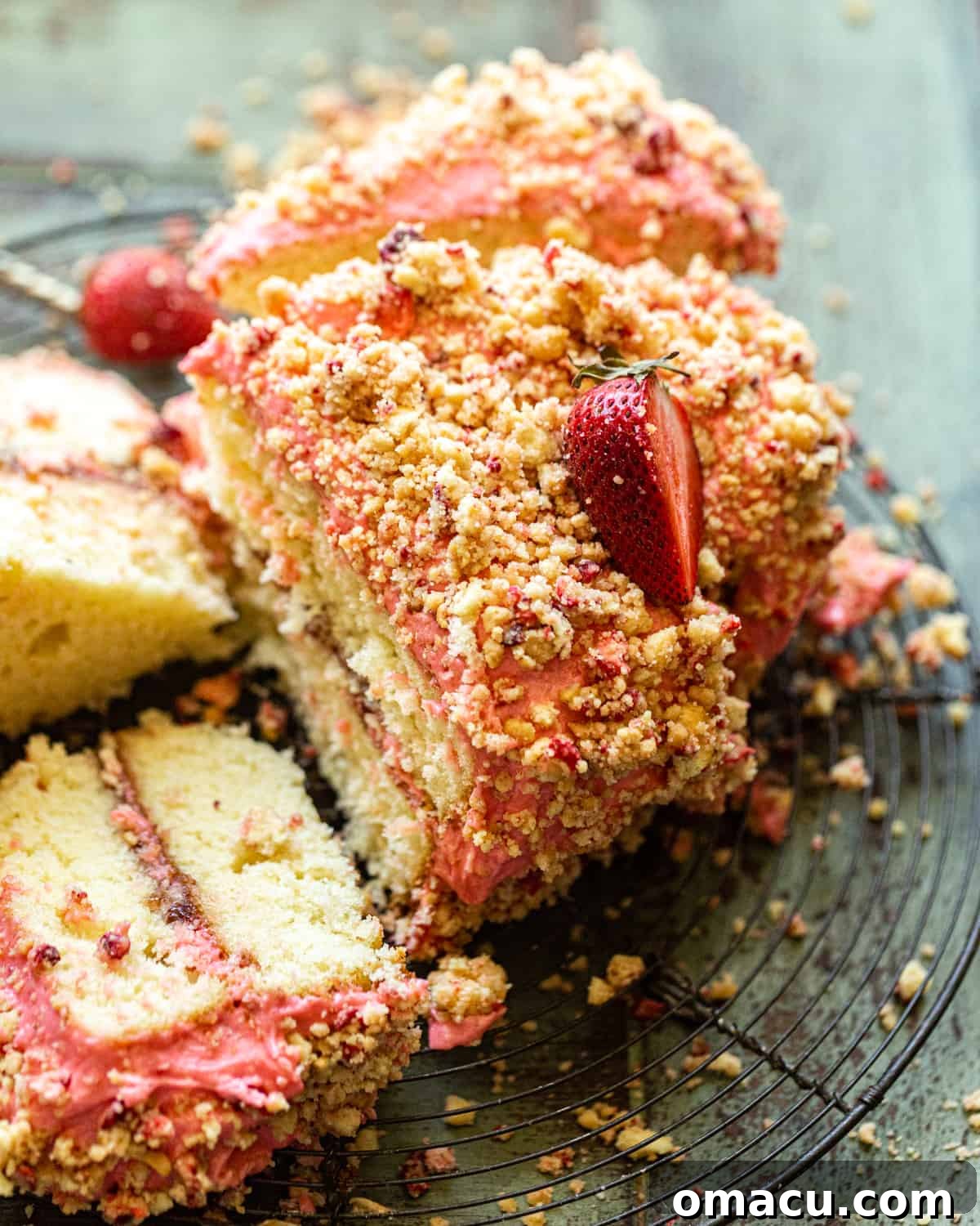 an up close photo of strawberry crunch cake with a slice removed.