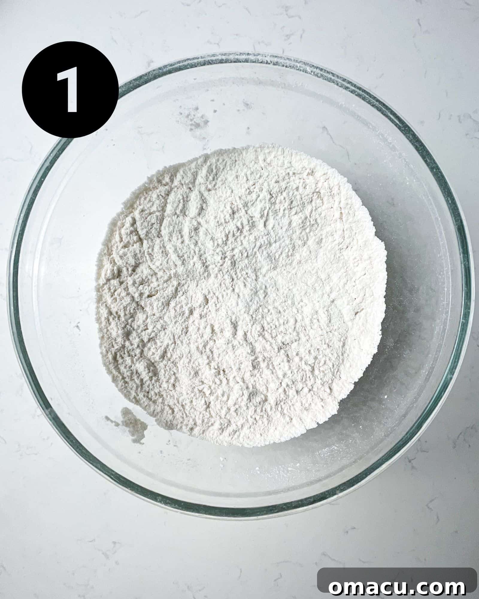 flour, baking powder, baking soda, and salt mixed together in a mixing bowl.