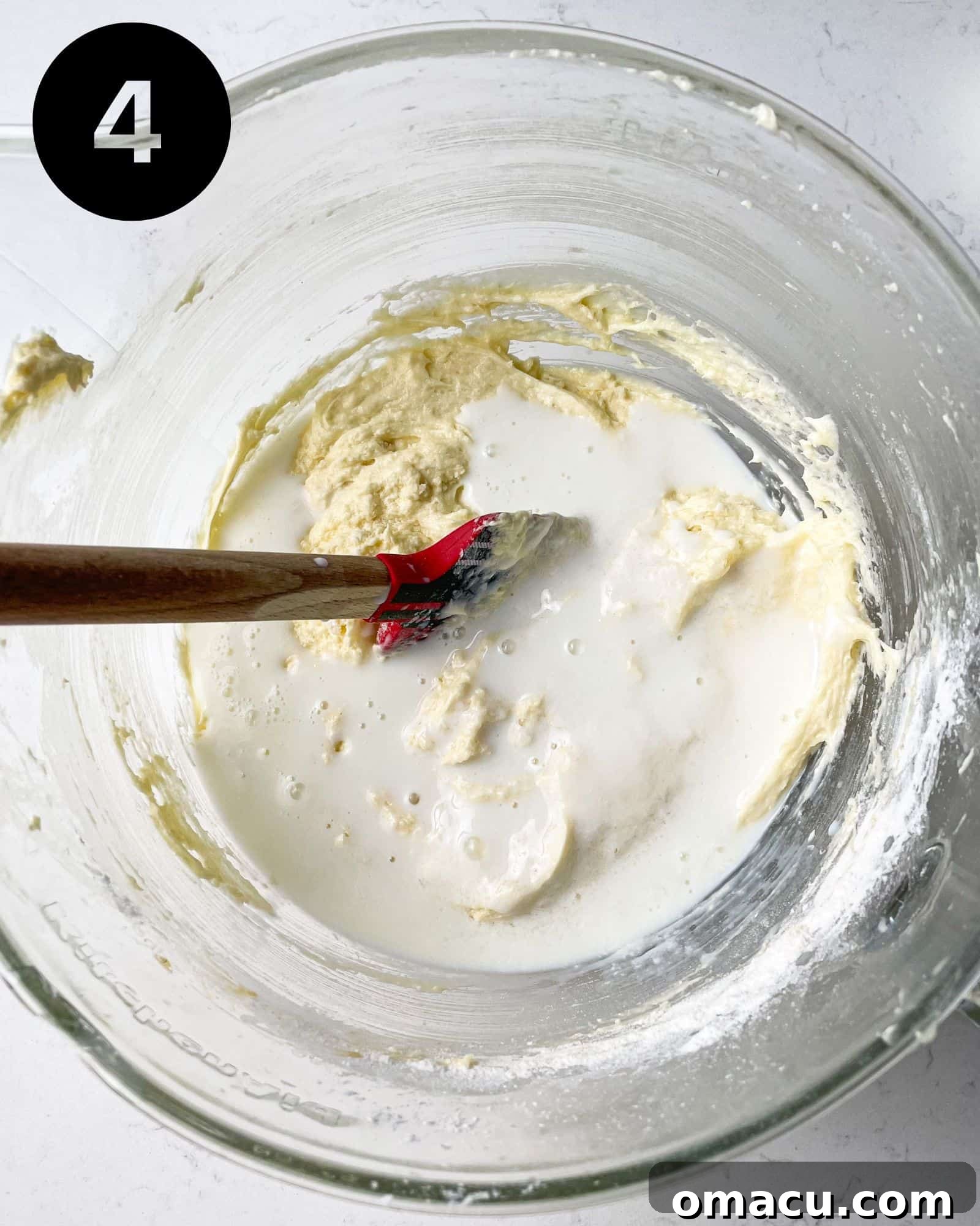 cake batter in a bowl with buttermilk being added.