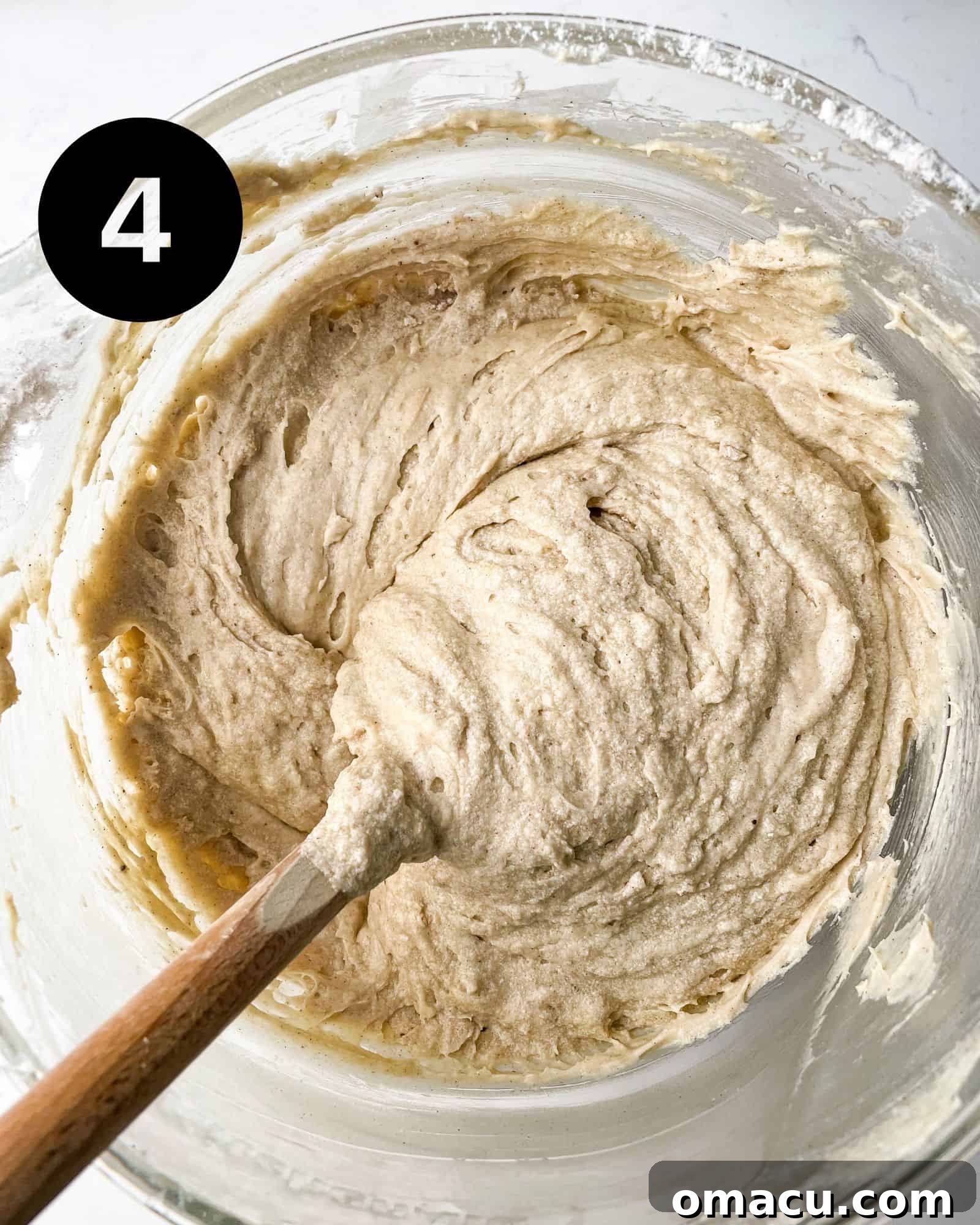 peach cobbler pound cake batter mixed together in a bowl with a silicone spatula.