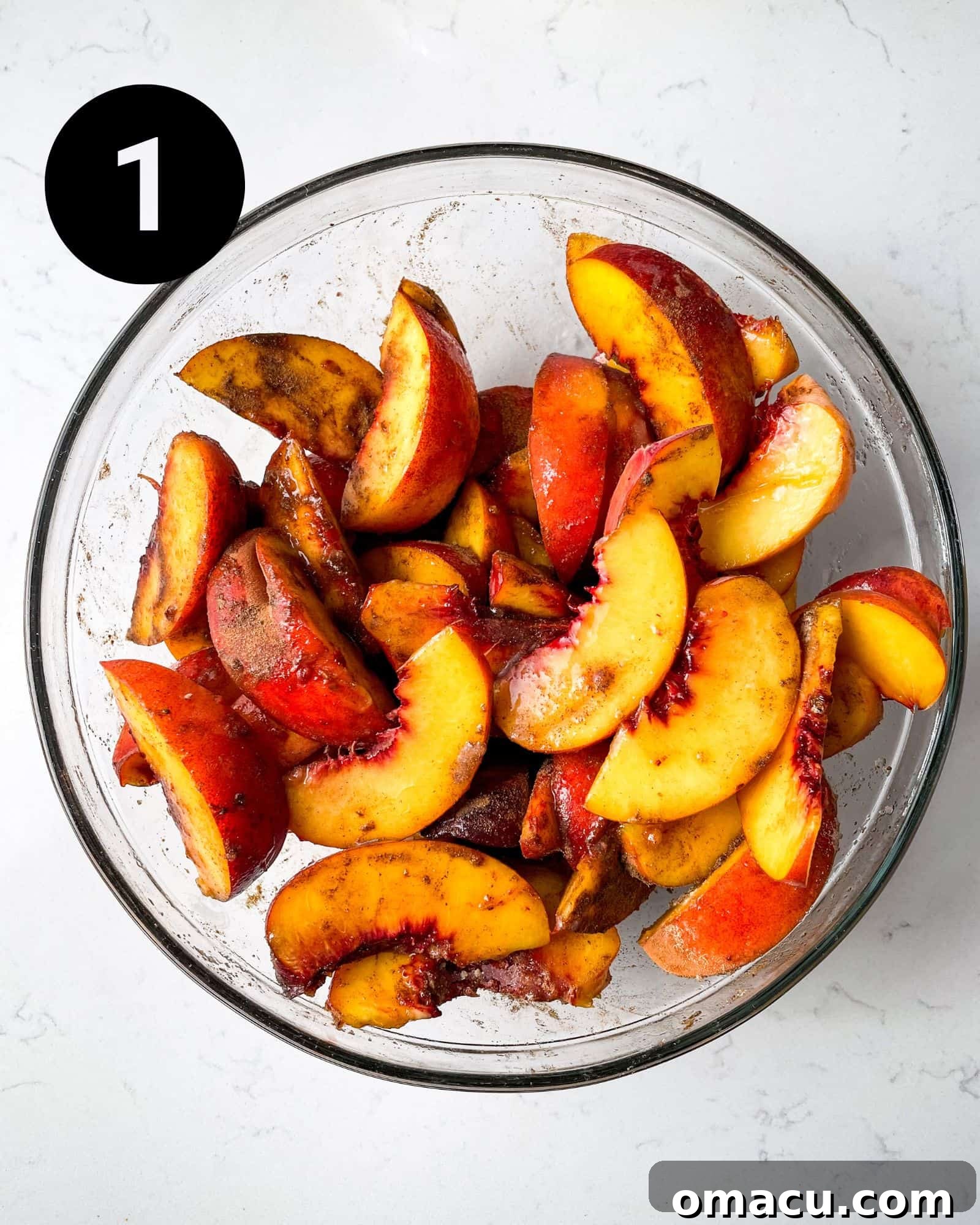 Fresh yellow peach slices thoroughly tossed with sugar, lemon juice, cinnamon, nutmeg, and ginger in a large mixing bowl.