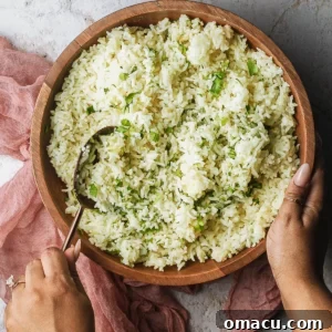 A bowl of fluffy white cilantro lime rice, flecked with green herbs and hints of lime zest.