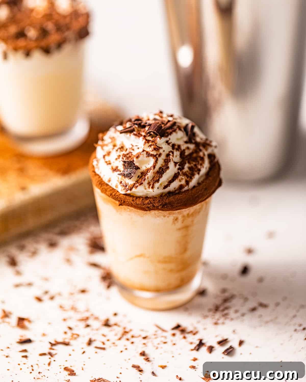A pristine shot glass on a white surface, showcasing the elegant presentation of a chocolate cake shot.