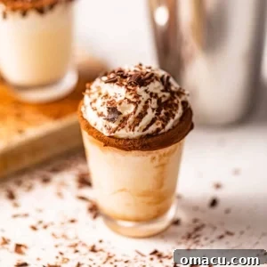 A shot glass on a white surface, ready for a delicious chocolate cake shot.