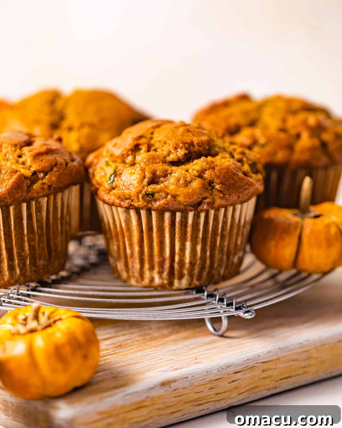 Soft and moist zucchini pumpkin muffins arranged beautifully on a rustic serving tray, showcasing their golden-brown tops and inviting texture.
