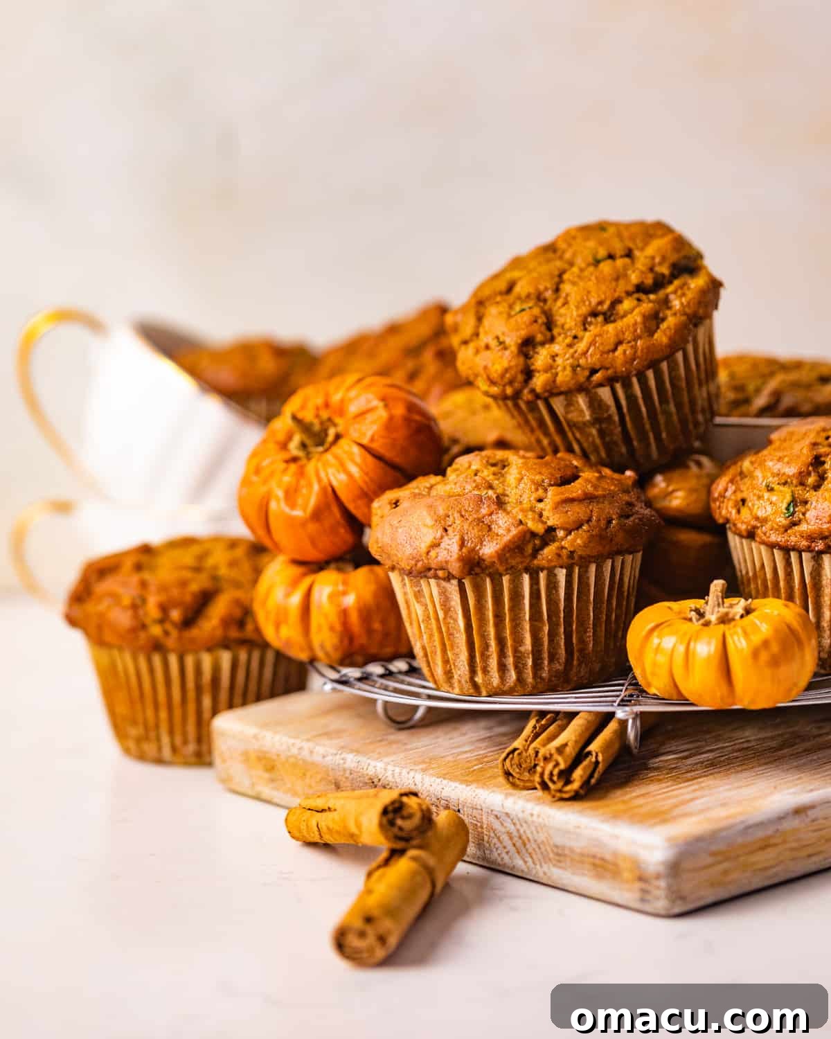 Stack of freshly baked zucchini pumpkin muffins, showcasing their golden-brown tops and inviting texture, ready to be enjoyed.
