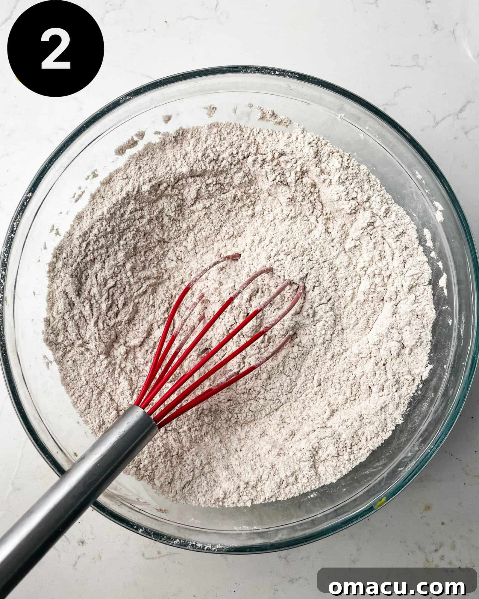 A bowl containing various dry ingredients like flour, baking soda, spices, and salt, perfectly mixed together.