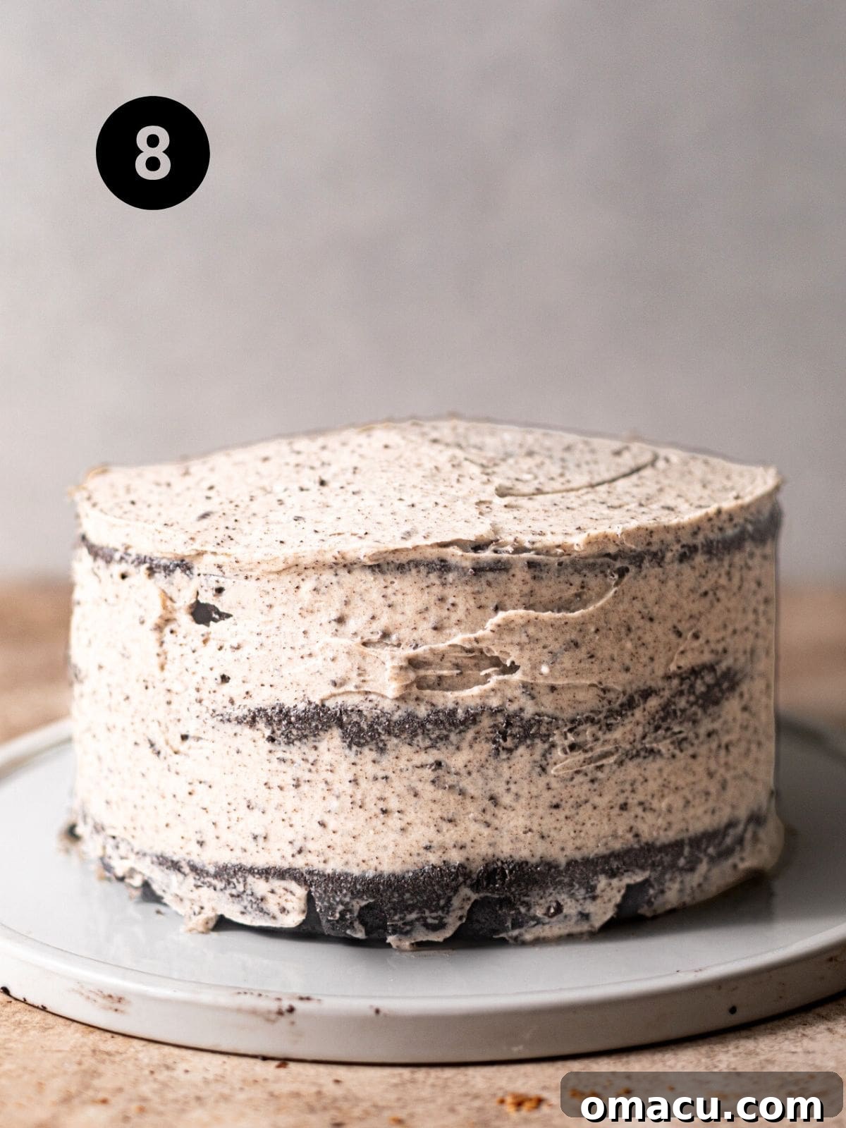 The fully frosted black velvet cake, coated in smooth Oreo cream cheese frosting, awaiting final garnishes.