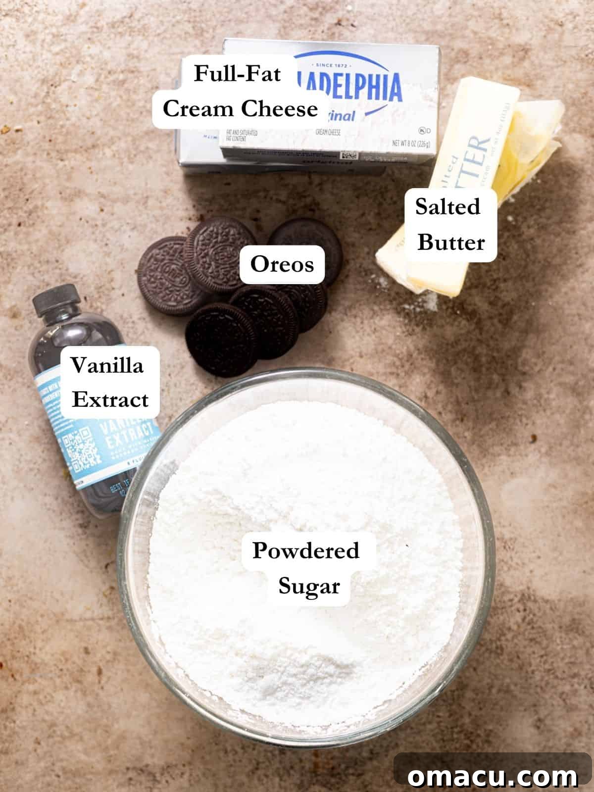 The simple yet crucial ingredients for Oreo cream cheese frosting laid out: butter, cream cheese, powdered sugar, and Oreo cookies.