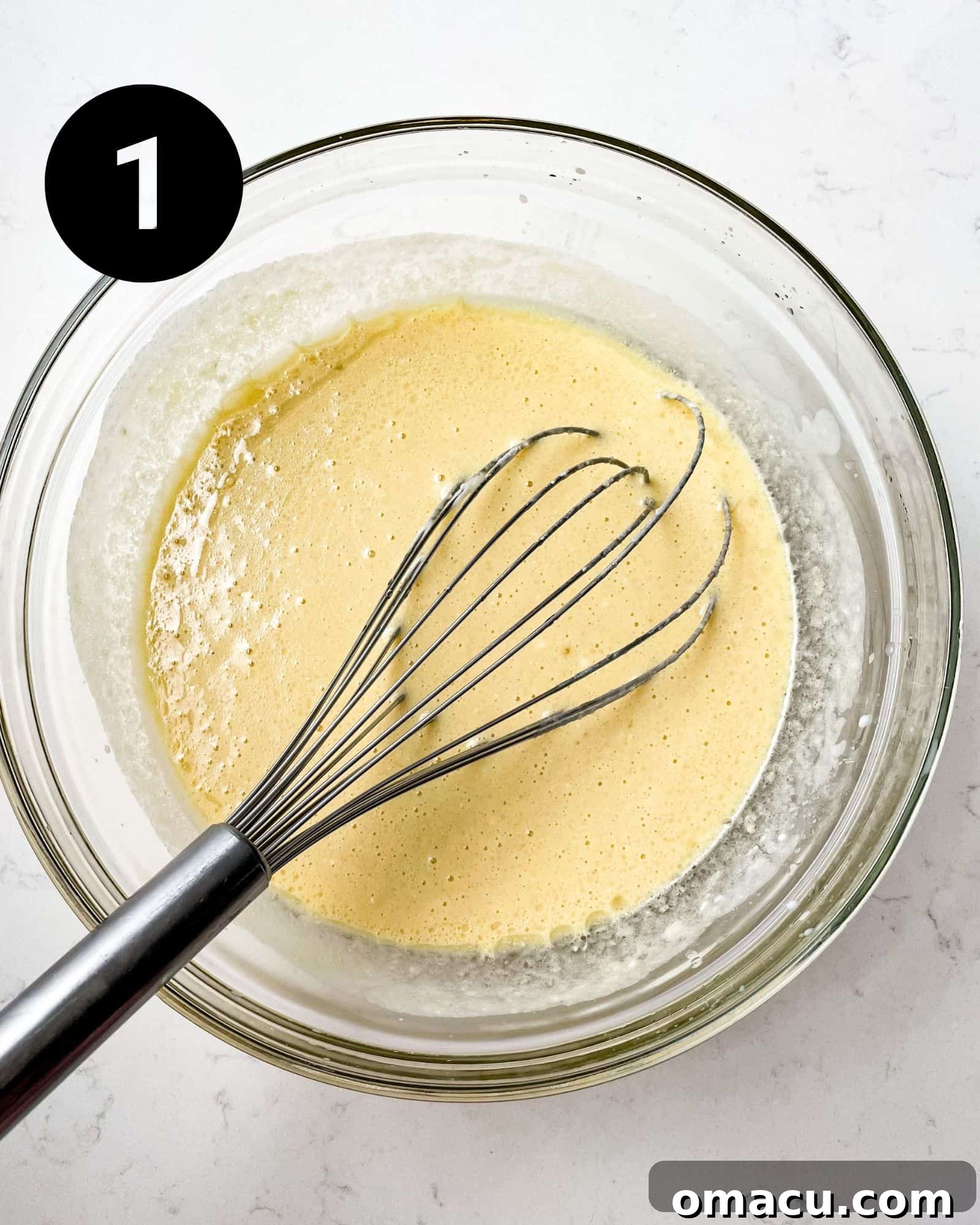 wet ingredients for sweet potato cornbread batter whisked together in a mixing bowl.