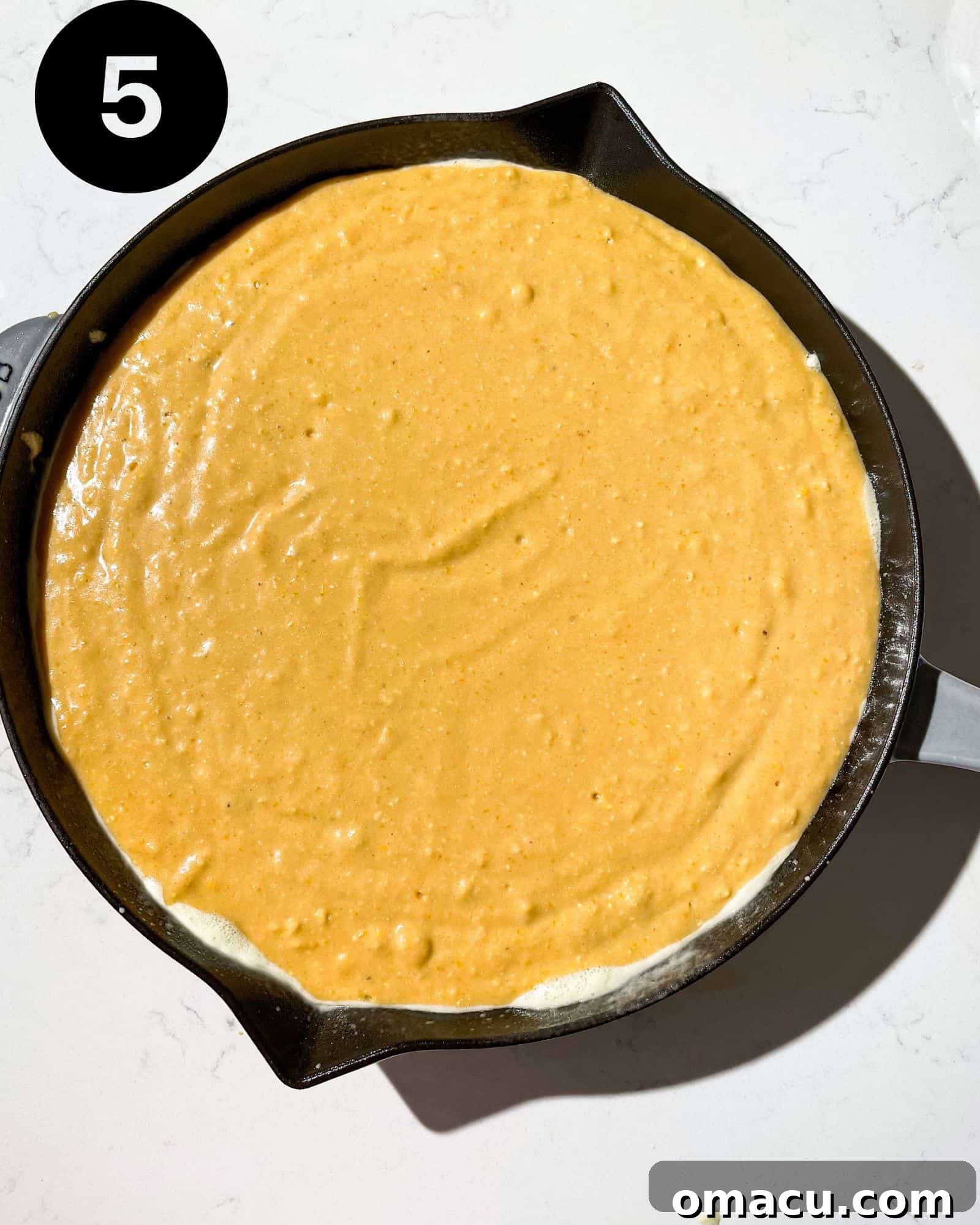 sweet potato cornbread baking in a cast iron skillet.