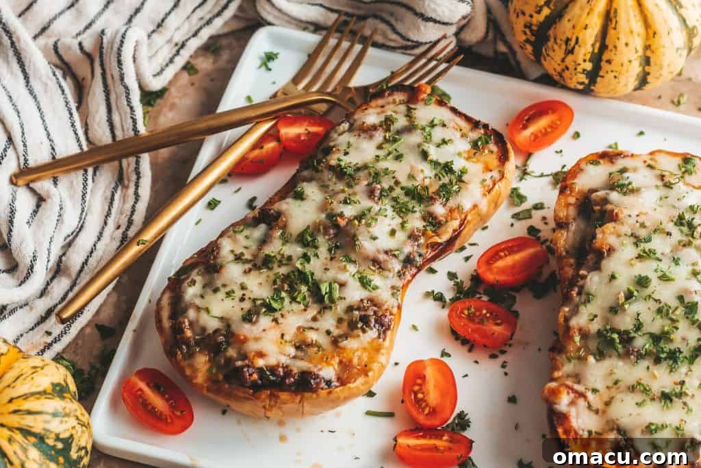 Close-up of a loaded butternut squash boat, highlighting the melted cheese topping and the hearty beef and vegetable filling.