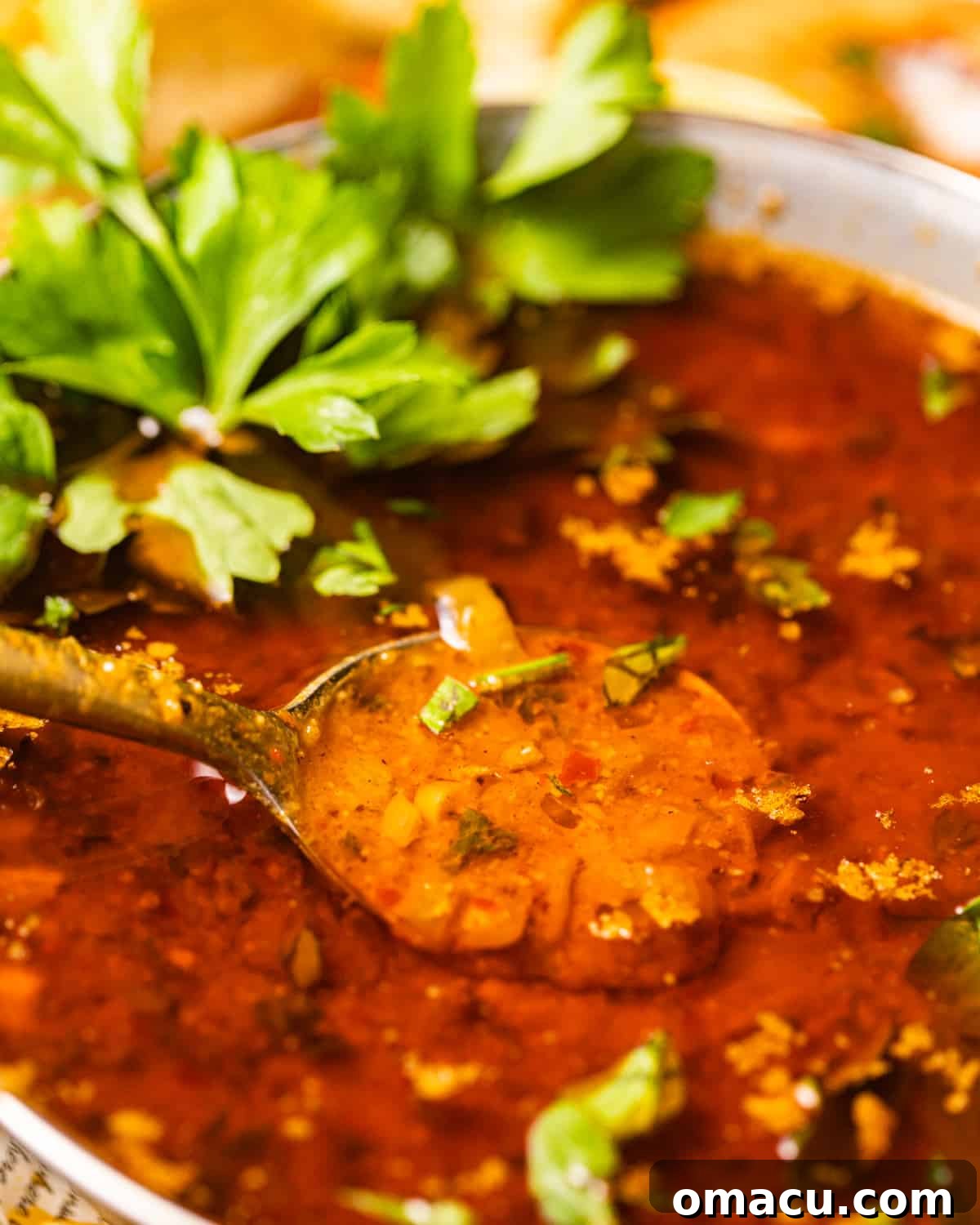 An inviting close-up photo of the rich, golden-brown seafood boil sauce in a rustic bowl, garnished with a sprinkle of vibrant fresh parsley, highlighting its luxurious texture and aromatic appeal.