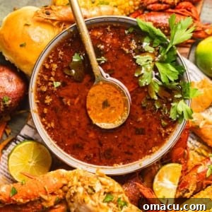 Close-up of the finished seafood boil sauce in a bowl, with a spoon, highlighting its inviting texture.