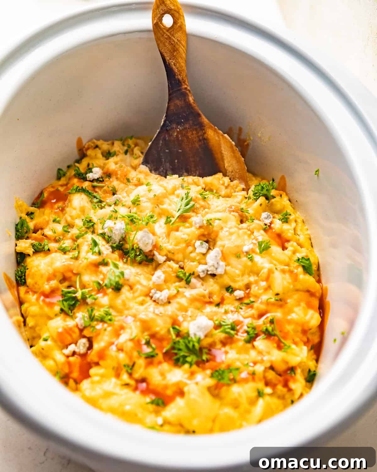 Close-up of bubbling Crockpot Buffalo Chicken Mac and Cheese in a slow cooker, showing melted cheese and chicken.