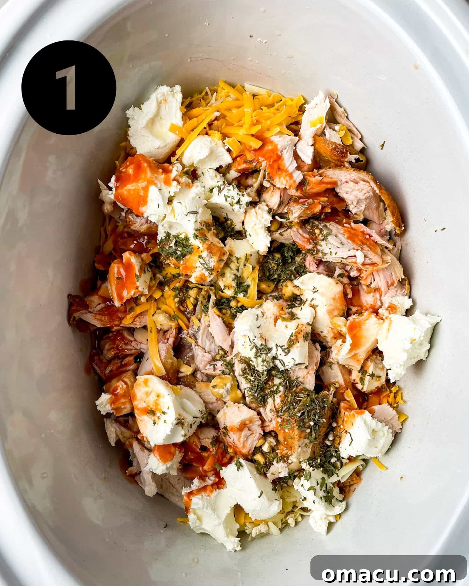 Step 1: Raw ingredients for buffalo mac and cheese combined in a crockpot, before cooking.