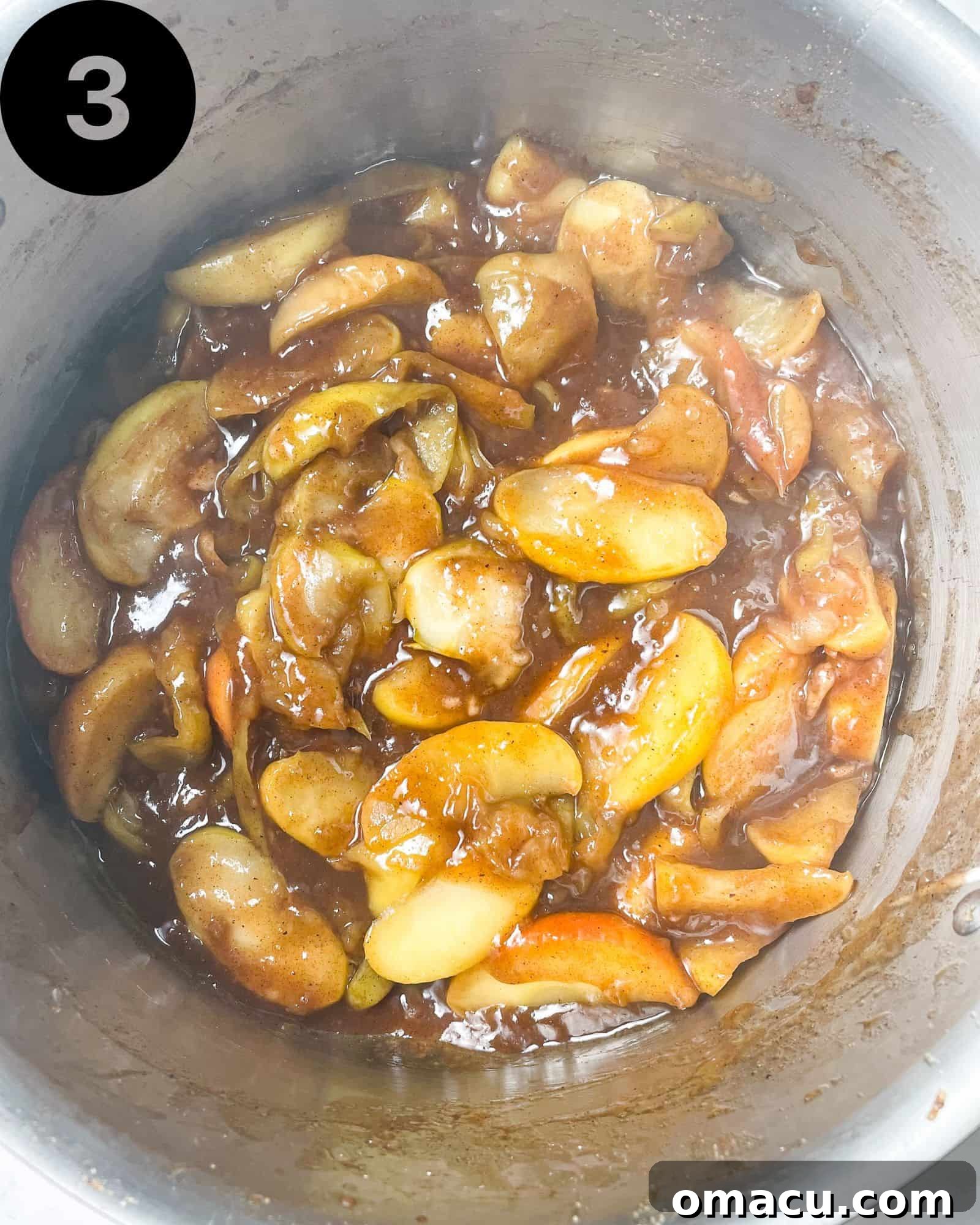 Cooked apple pie filling in a large pot, looking thick and glossy, ready to cool.