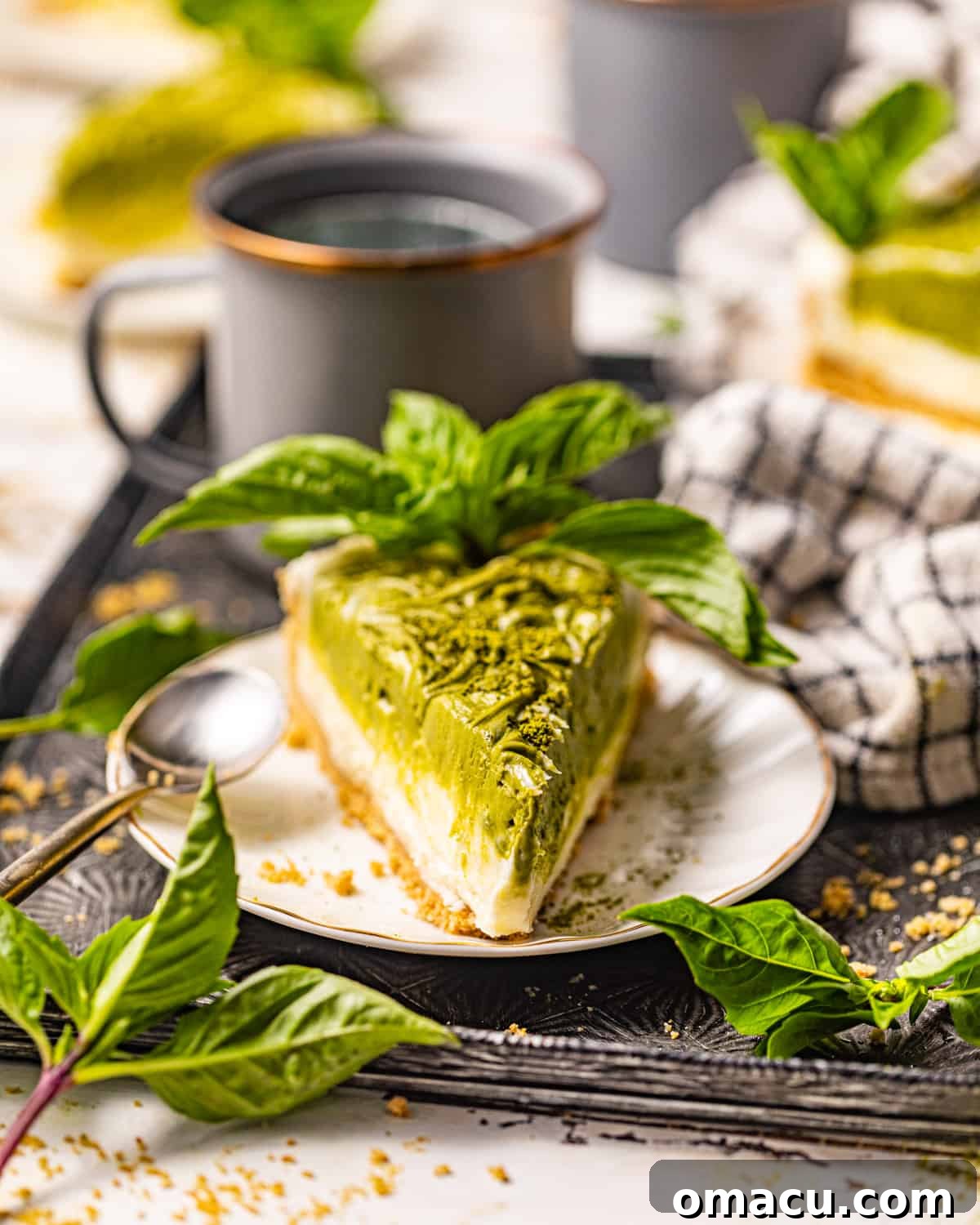 A close-up of a slice of vibrant green matcha cheesecake on a plate.
