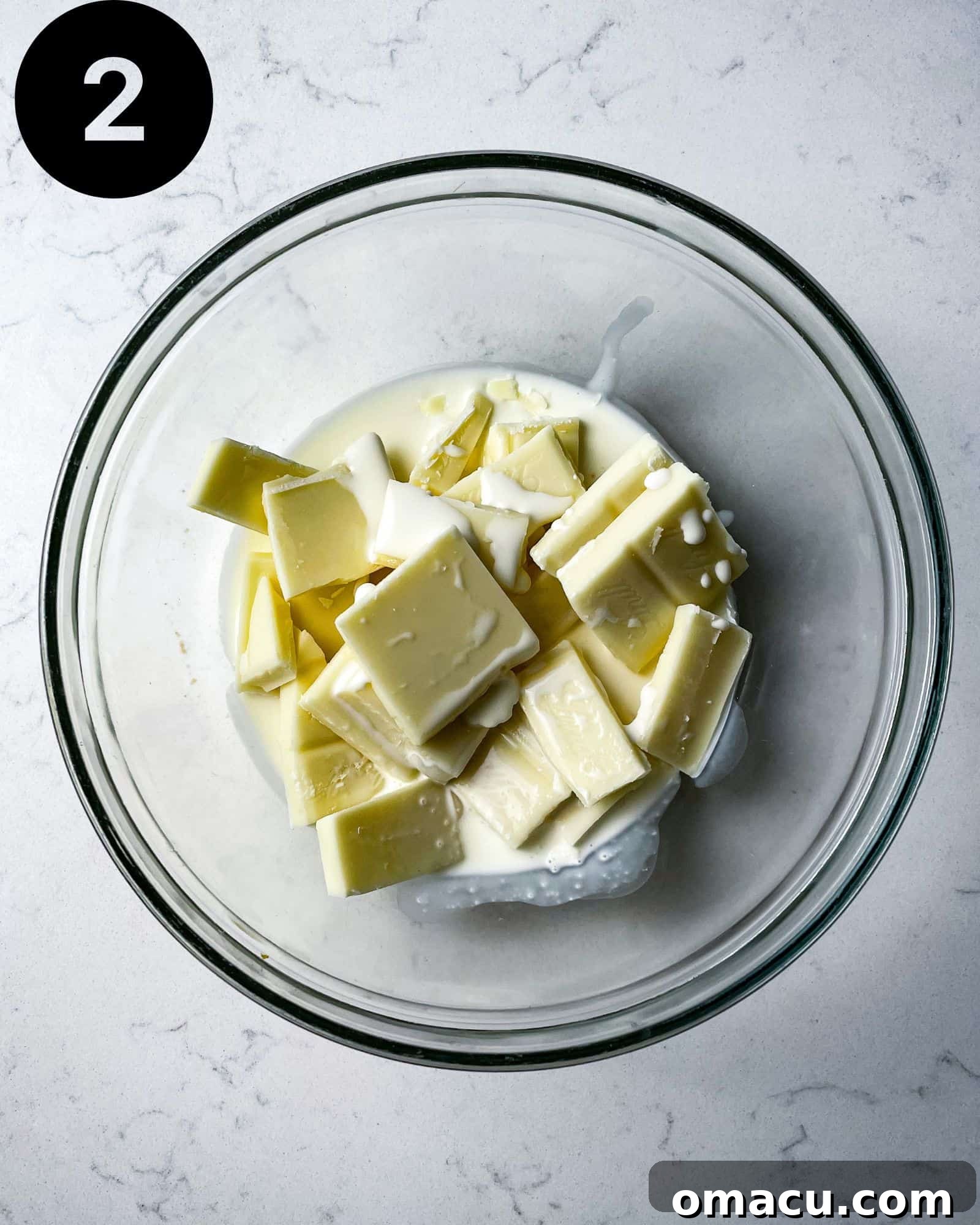 White chocolate and heavy cream combining in a bowl before melting.