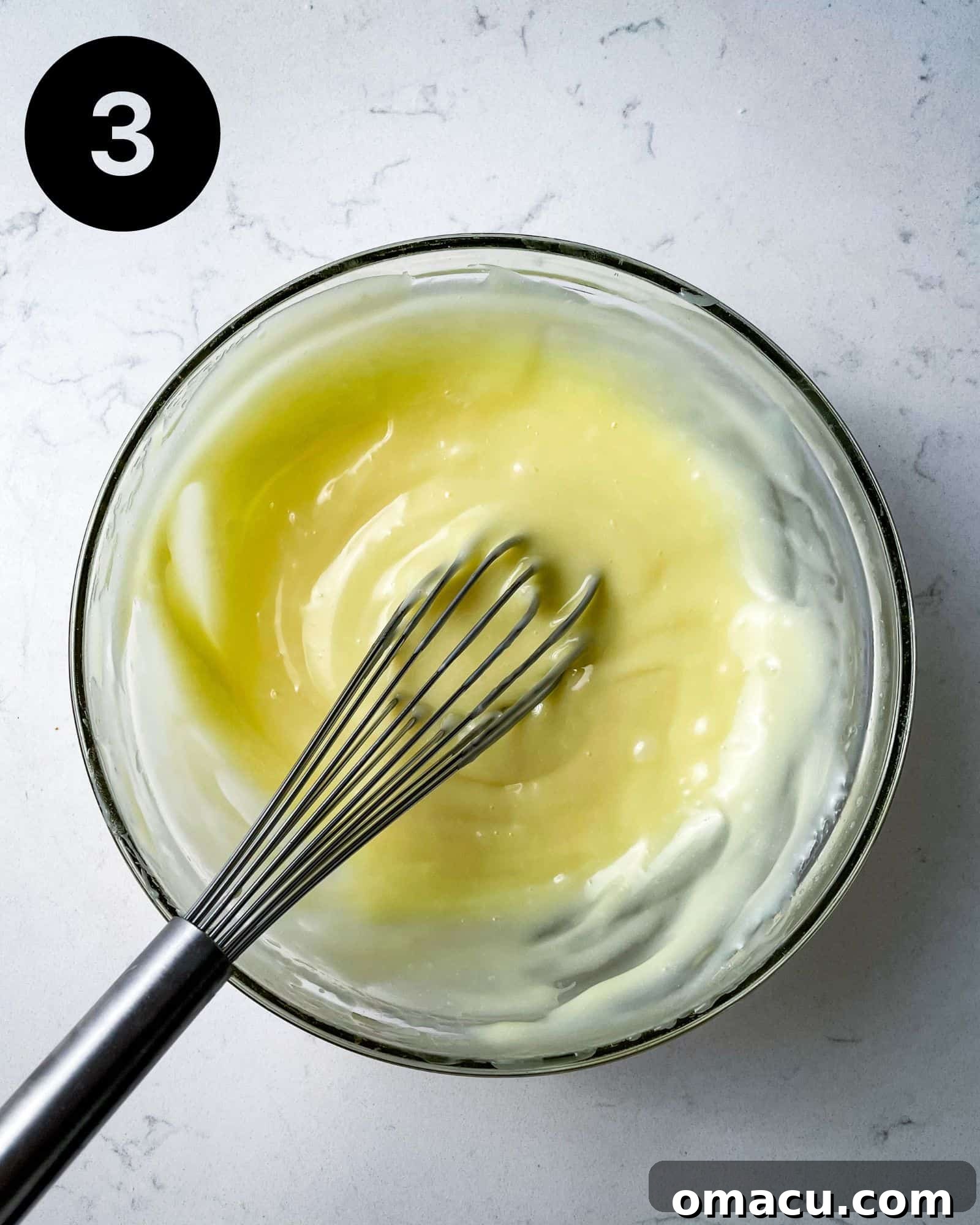 Smooth, melted white chocolate ganache in a bowl, cooling down.