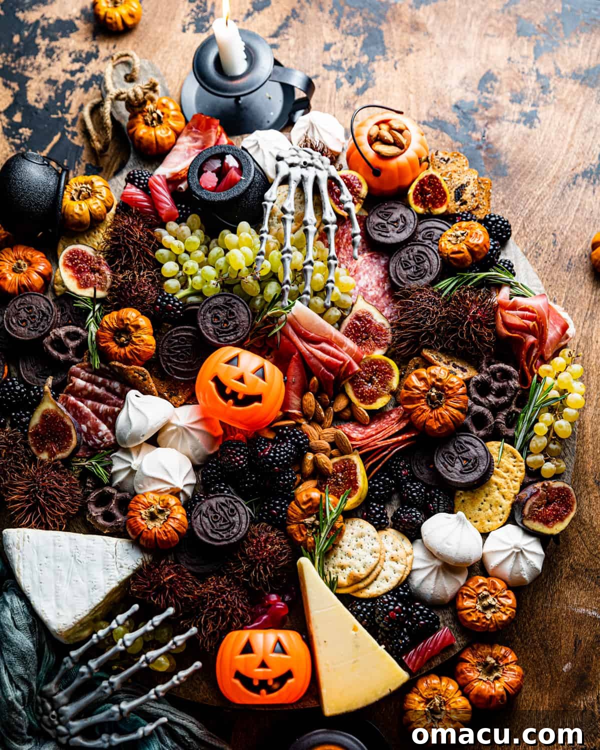 A Halloween Charcuterie Board expertly arranged on a table amidst spooky Halloween decorations.