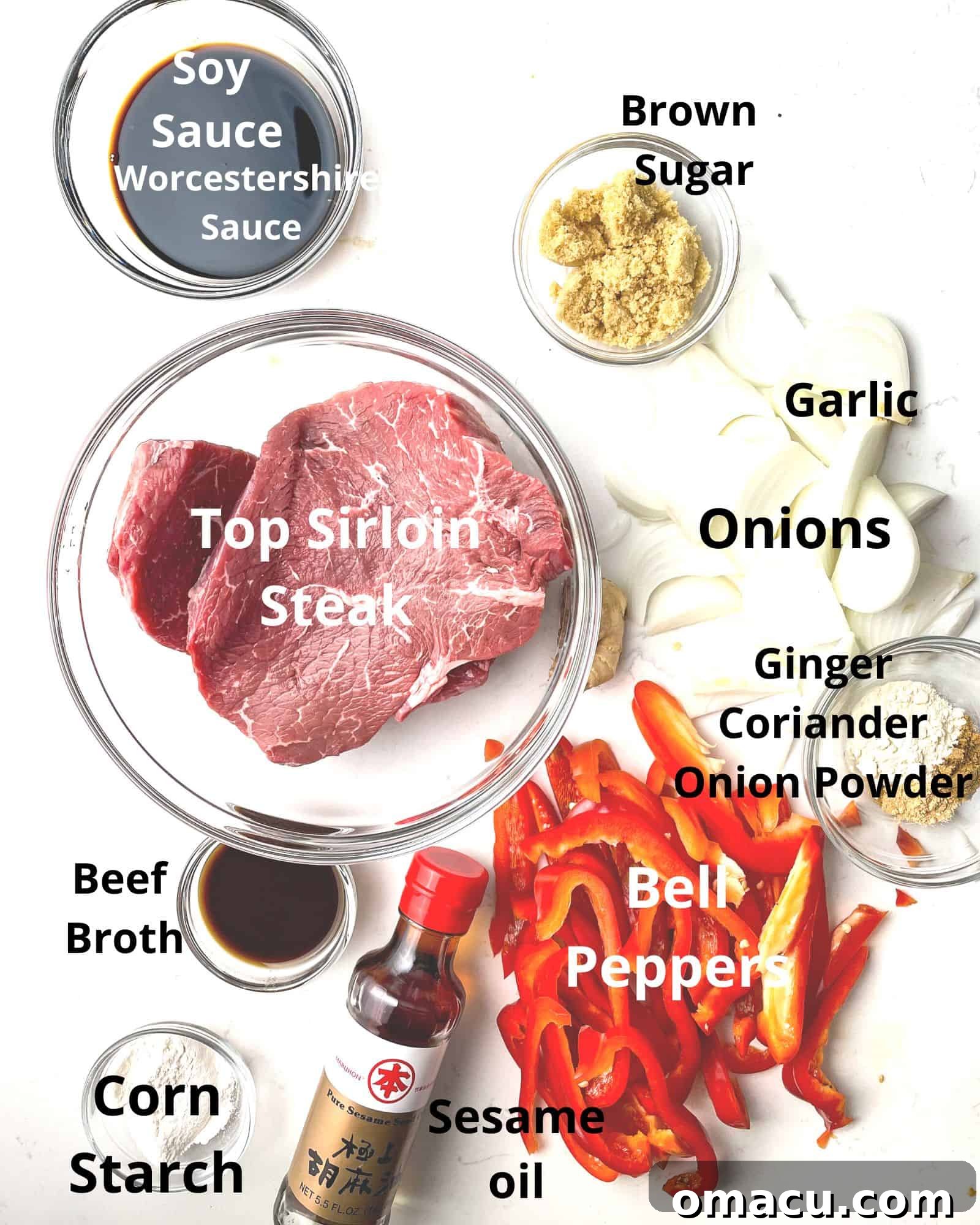 Ingredients laid out for making pepper steak: sirloin steak, soy sauce, onions, garlic, bell peppers, Worcestershire sauce, brown sugar, sesame oil, corn starch, and beef broth.