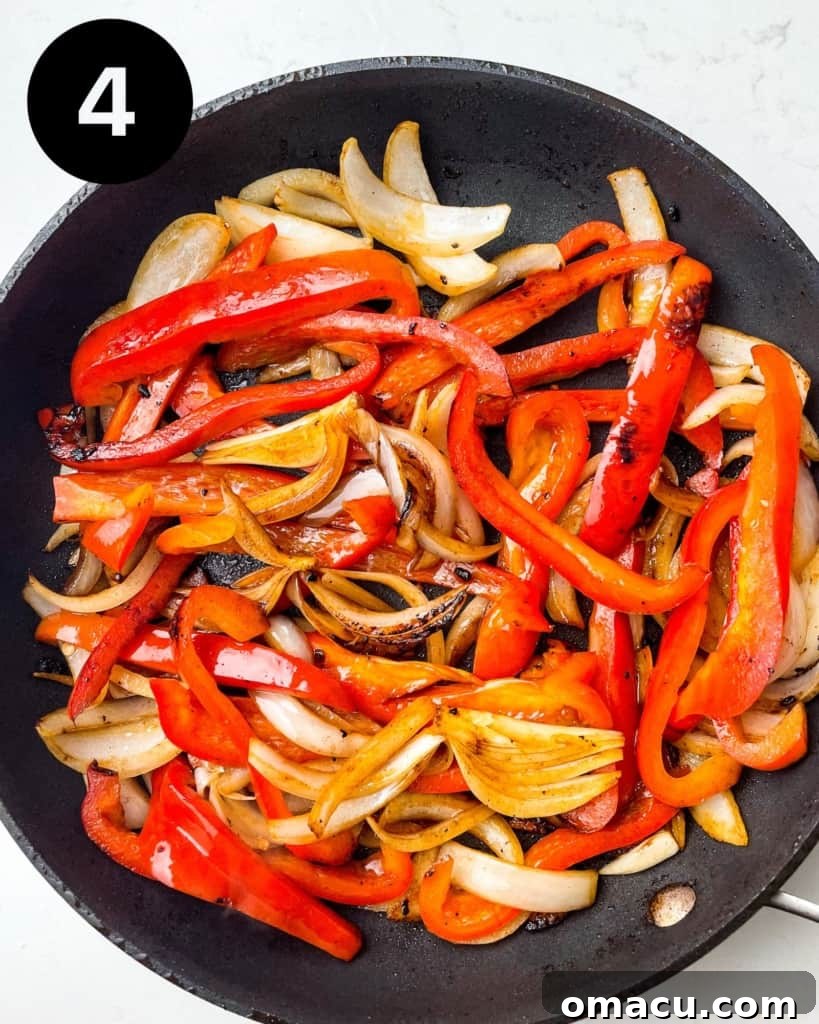 Stir-fried onions, bell peppers, and garlic in a skillet.