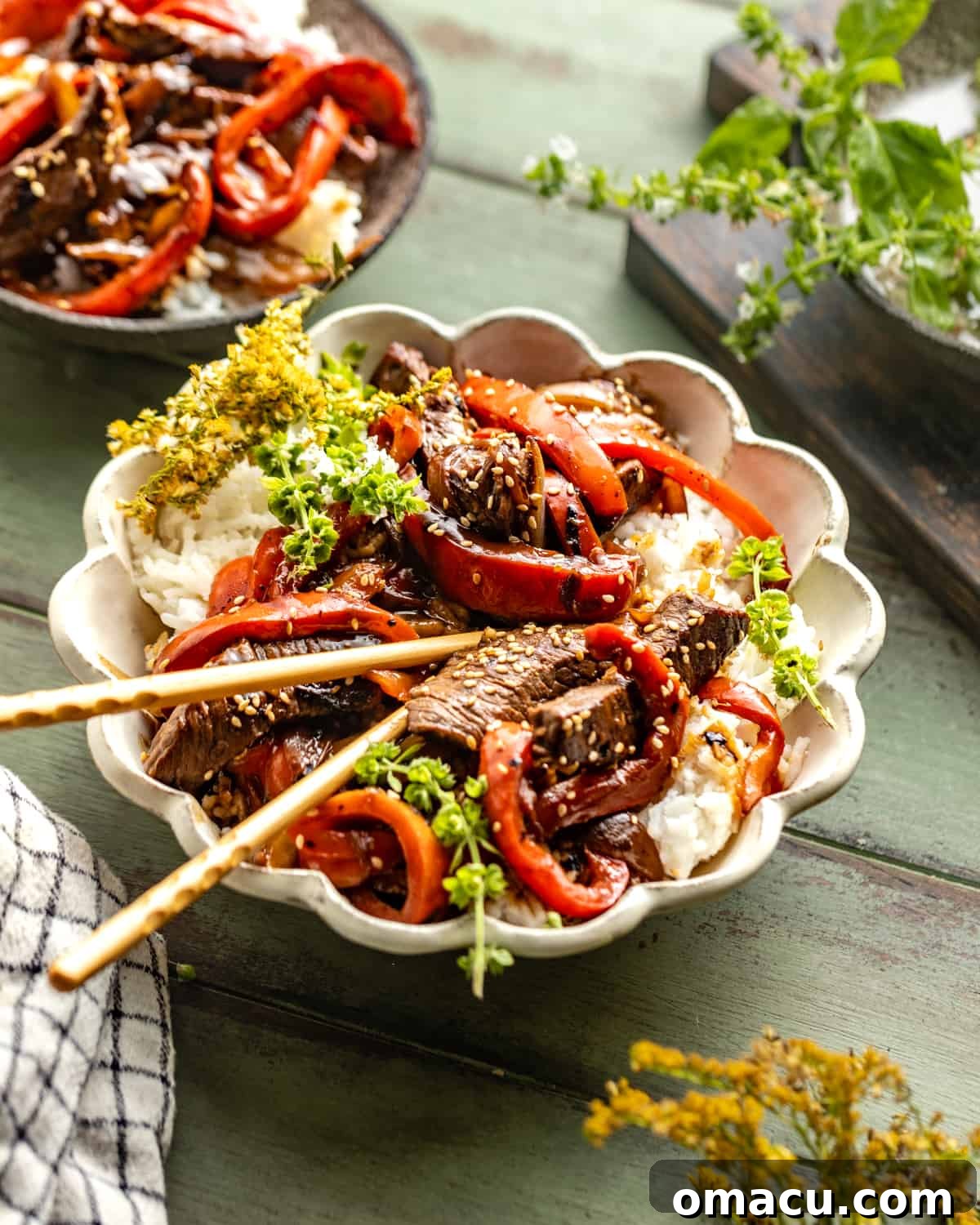 Pepper steak recipe in a bowl with chopsticks, ready to eat.