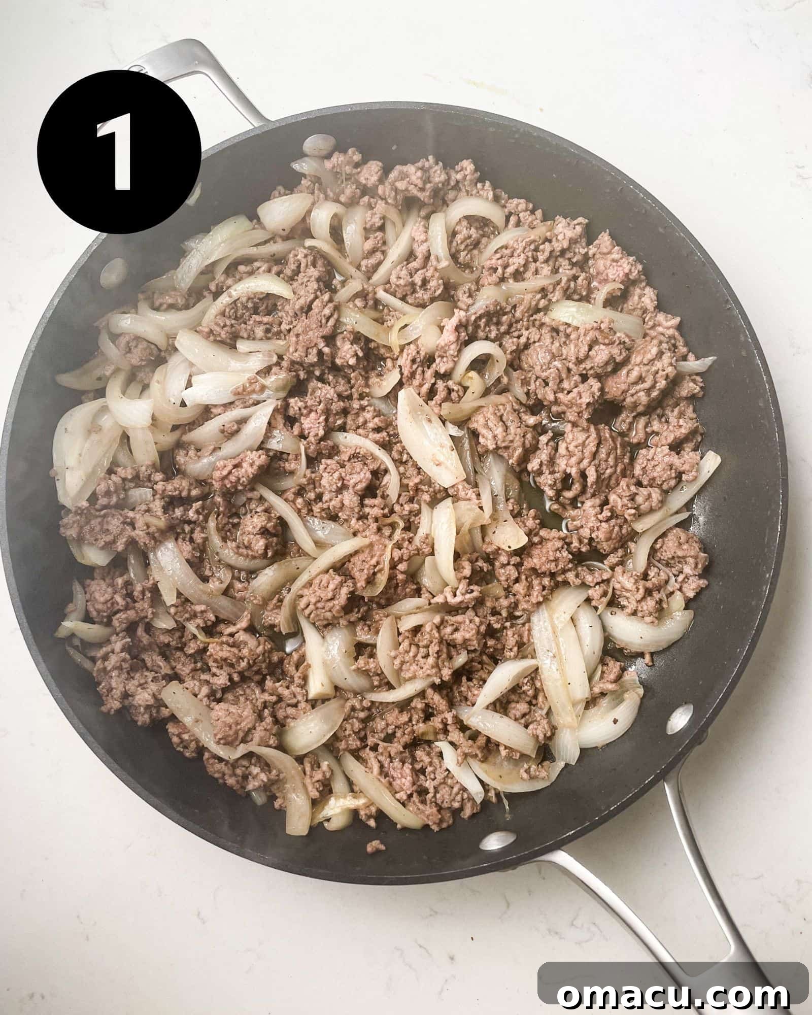 ground beef and onions sizzling in a skillet.