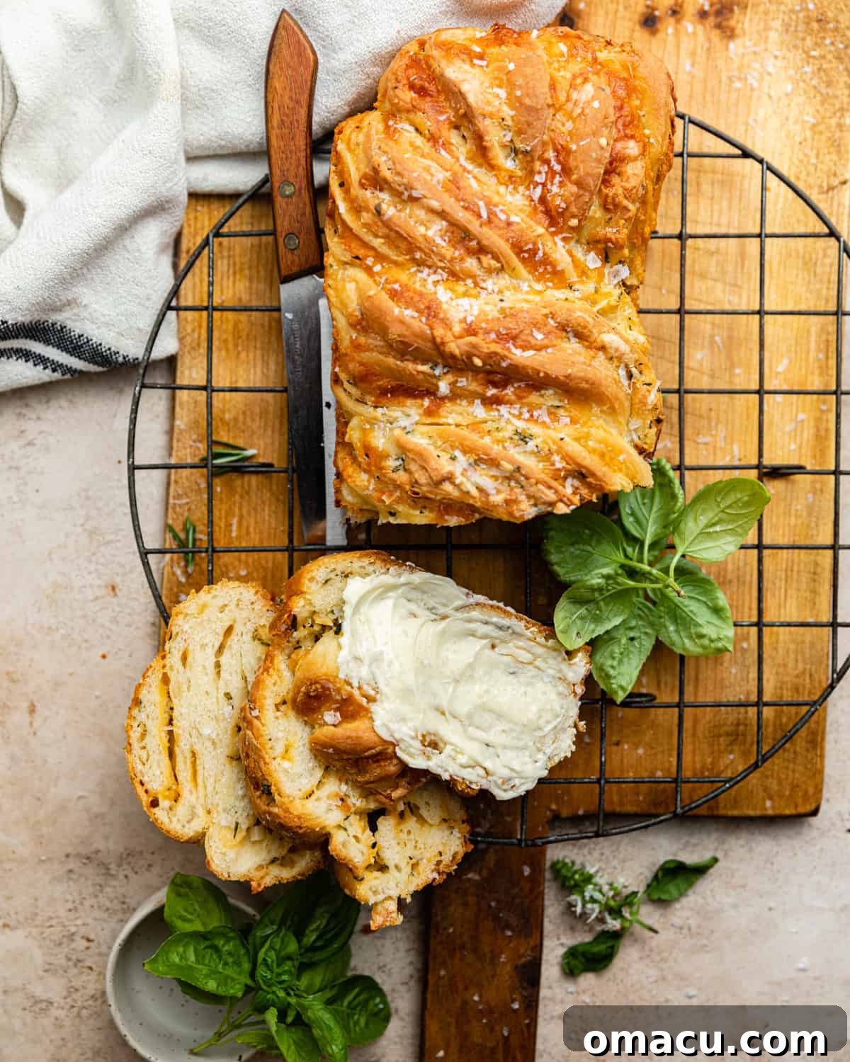 A freshly baked, golden brown savory cheese babka loaf on a wooden cutting board, ready to be sliced.