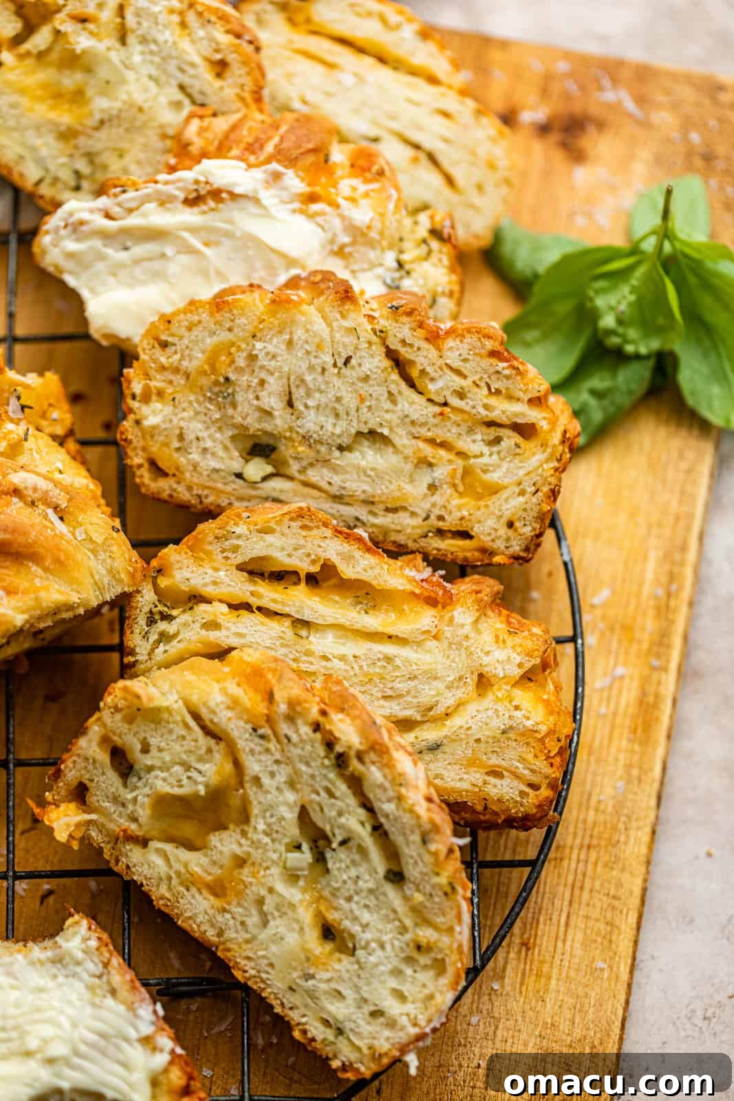 Slices of savory cheese babka on a cooling rack, showing the beautiful layers of cheese and herbs.