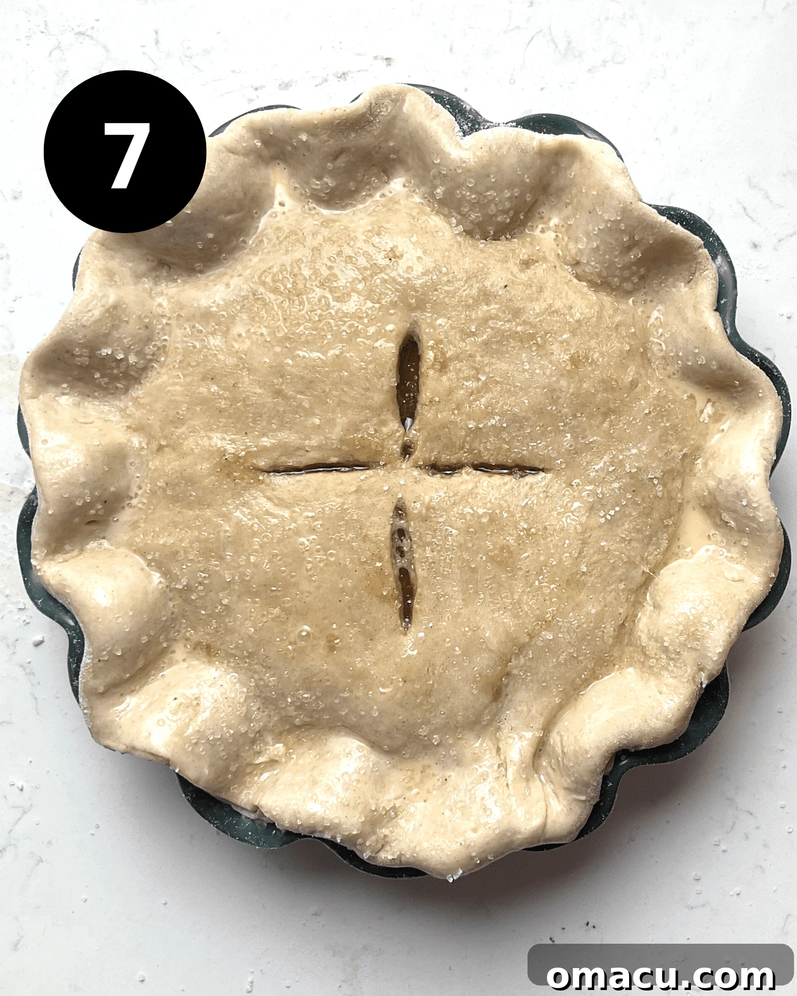 An unbaked maple apple pie, beautifully assembled with its top crust, crimped edges, and ready for the oven.