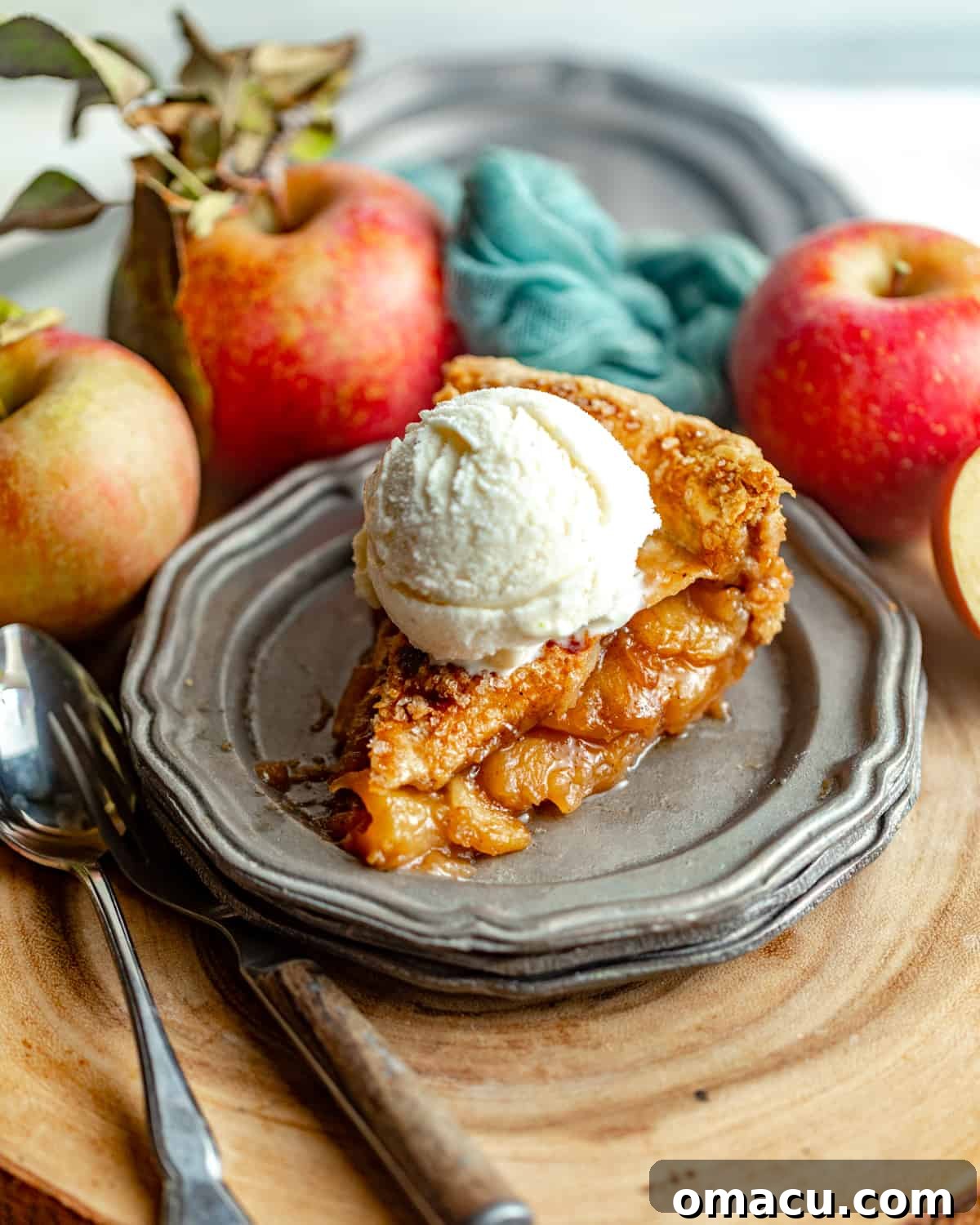 A delectable slice of maple apple pie on a simple white plate, adorned with a swirl of melting vanilla ice cream, ready to be savored.