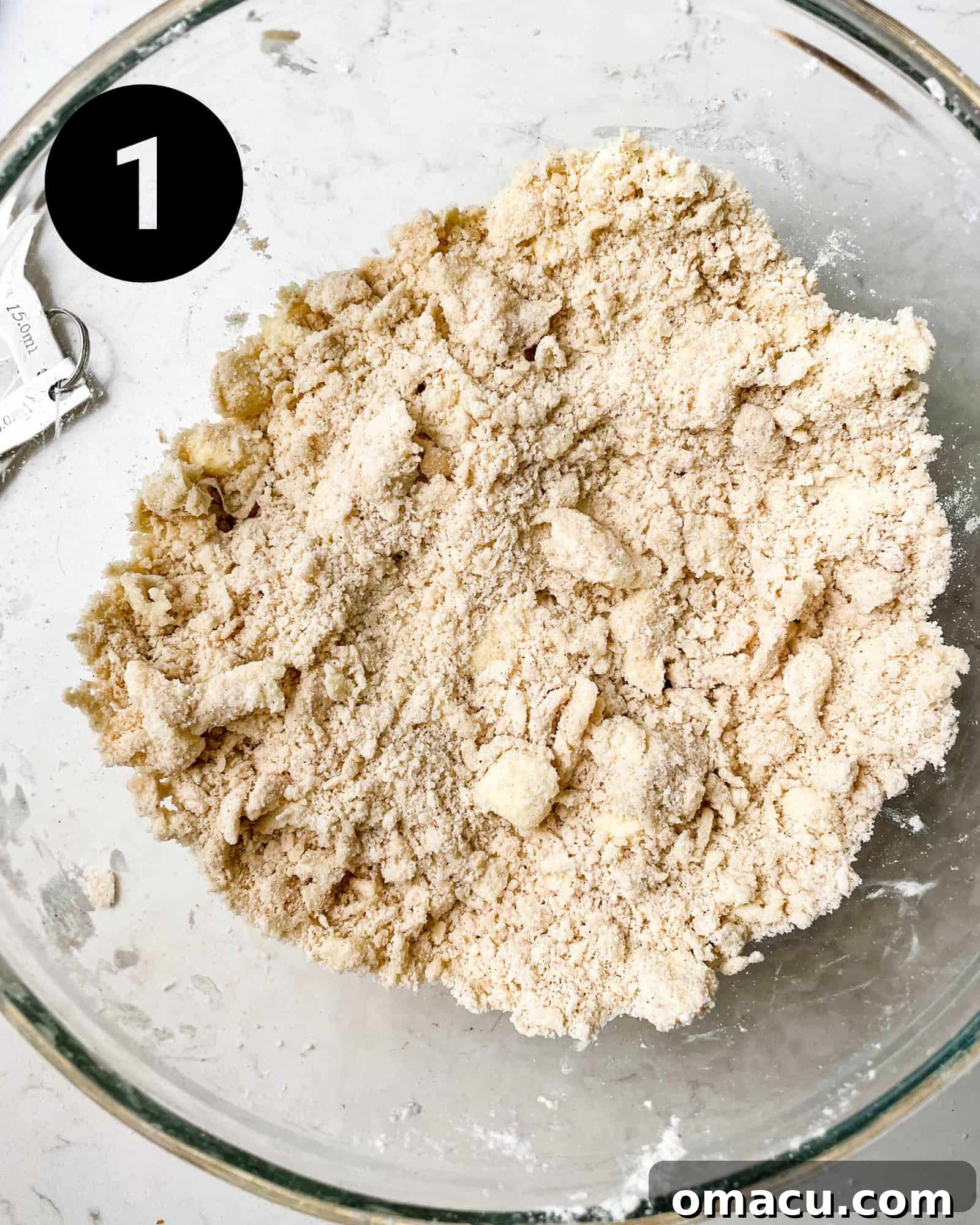 Freshly mixed pie crust dough in a large bowl, showing the visible butter chunks, essential for a flaky texture.