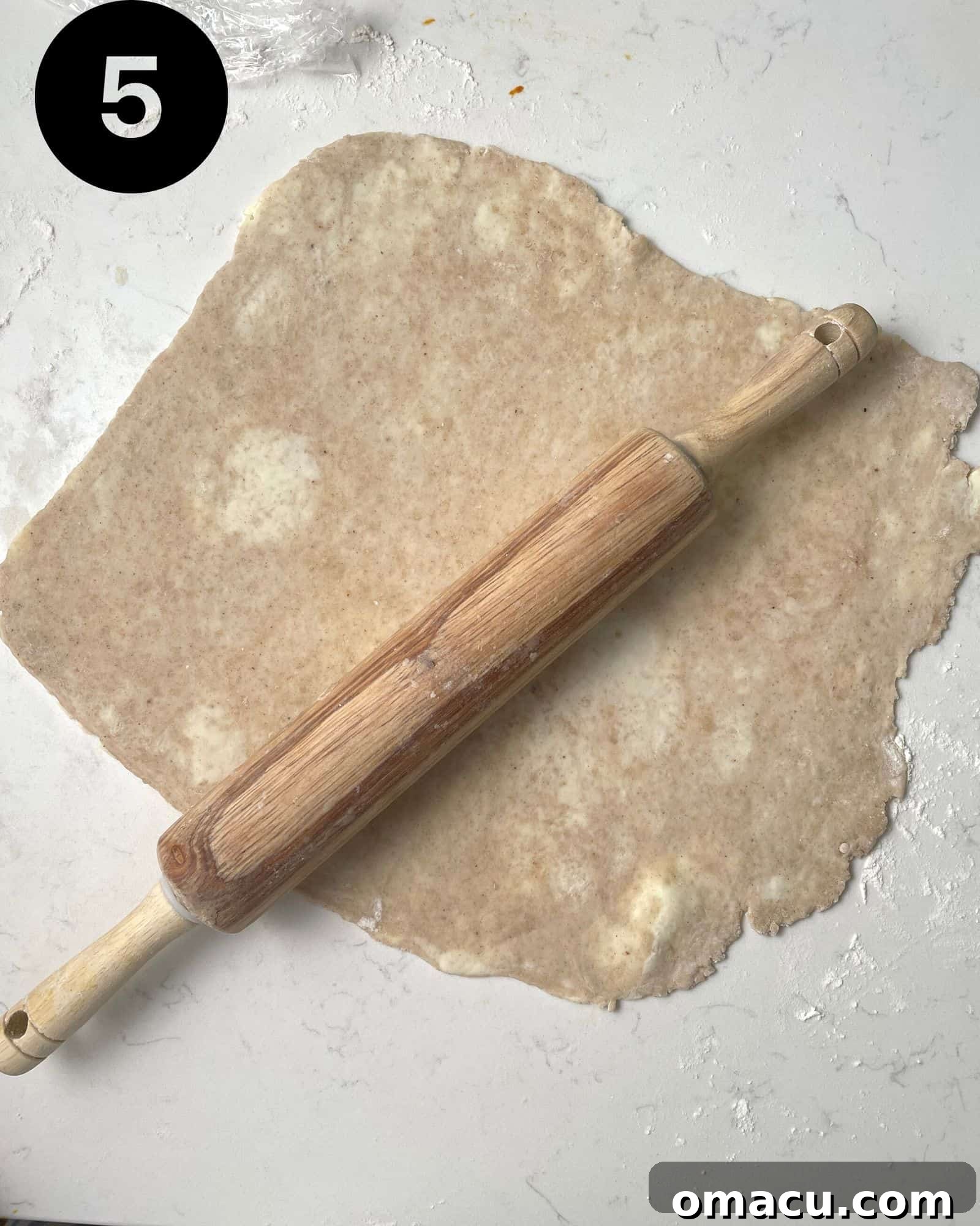 Pie dough skillfully rolled out on a floured work surface, showcasing its smooth, even texture and readiness for assembly.