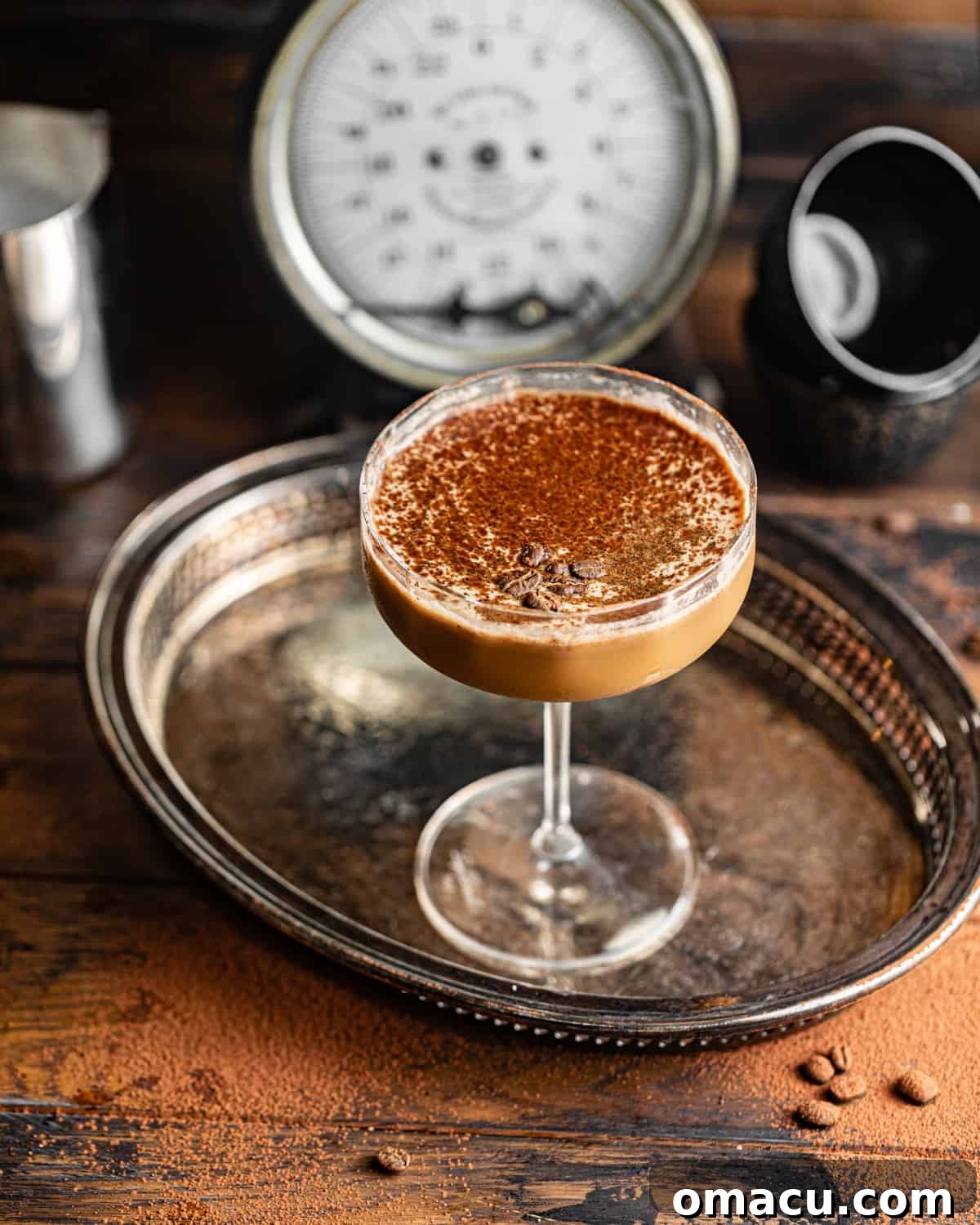 An elegantly prepared espresso martini in a coupe glass, garnished with coffee beans.