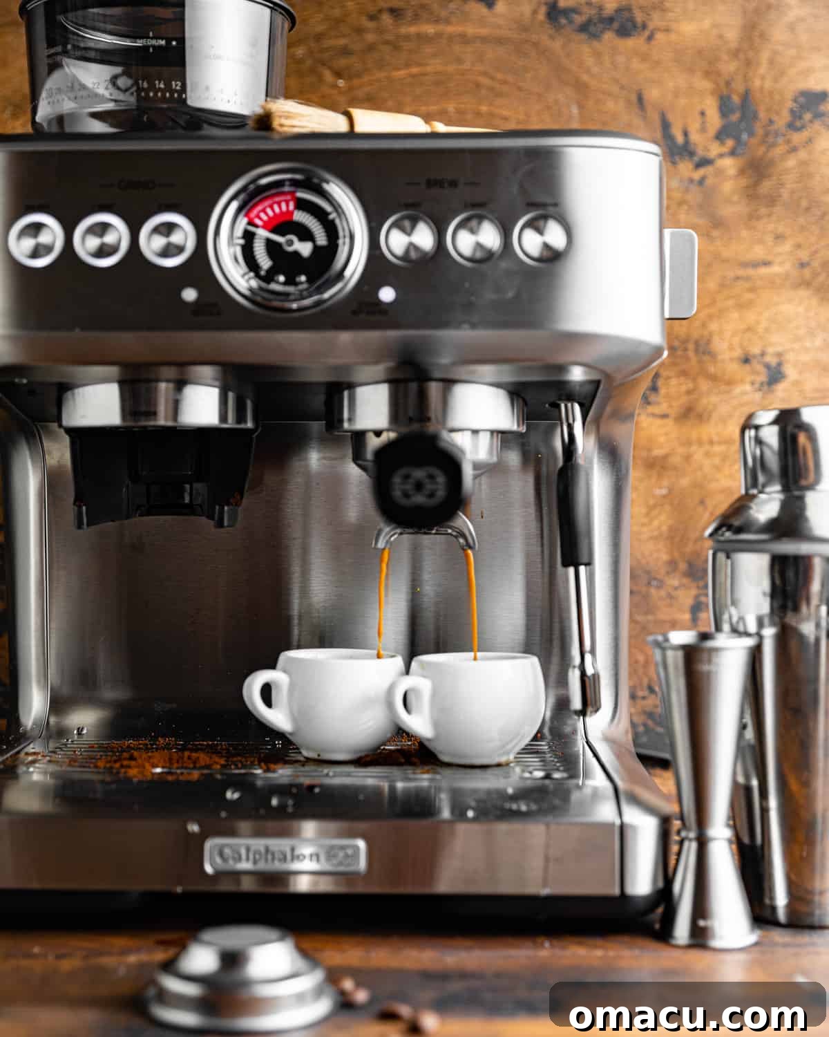 An espresso machine extracting espresso into two small cups, showcasing the brewing process.