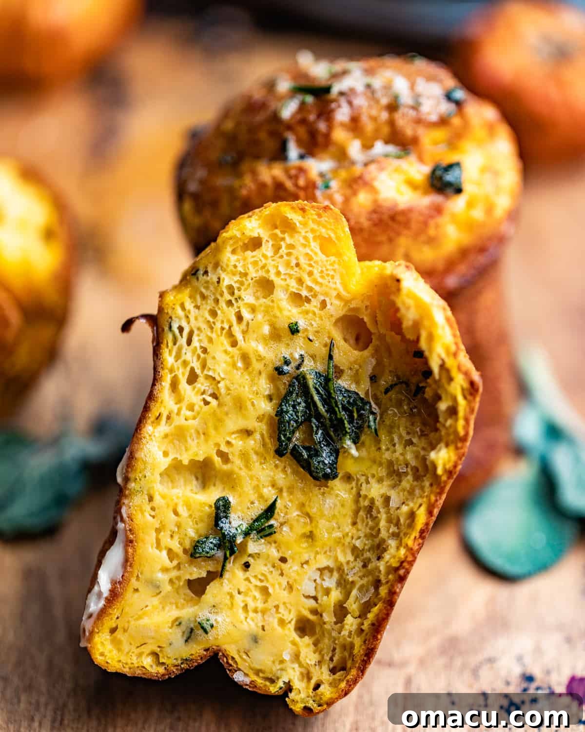 A pumpkin popover cut in half, revealing its moist and airy interior texture.
