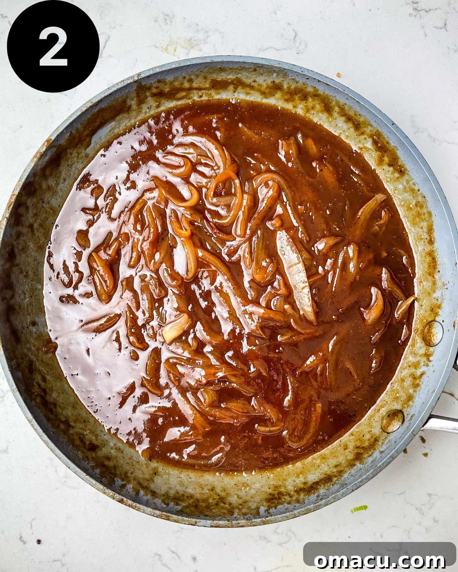 All the bbq sauce ingredients simmering together in a skillet, creating a rich, dark mixture.