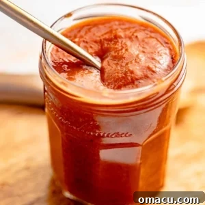 honey bbq sauce in a jar with a spoon.