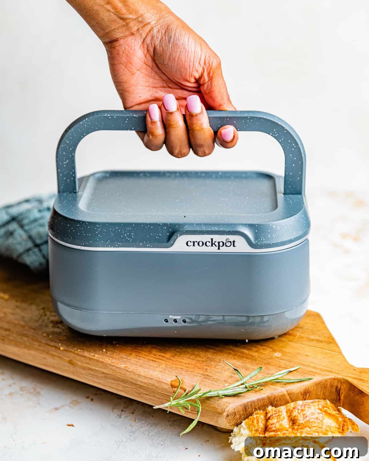 a hand holding a lunch box.