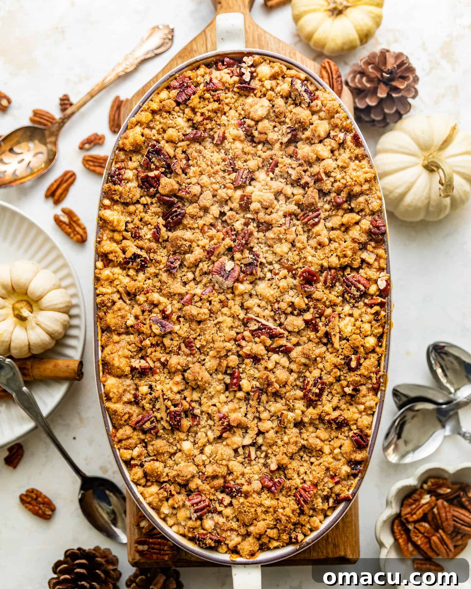 A delicious Bourbon Sweet Potato Casserole in a baking dish, ready to be served at a holiday meal, topped with golden-brown pecan streusel.