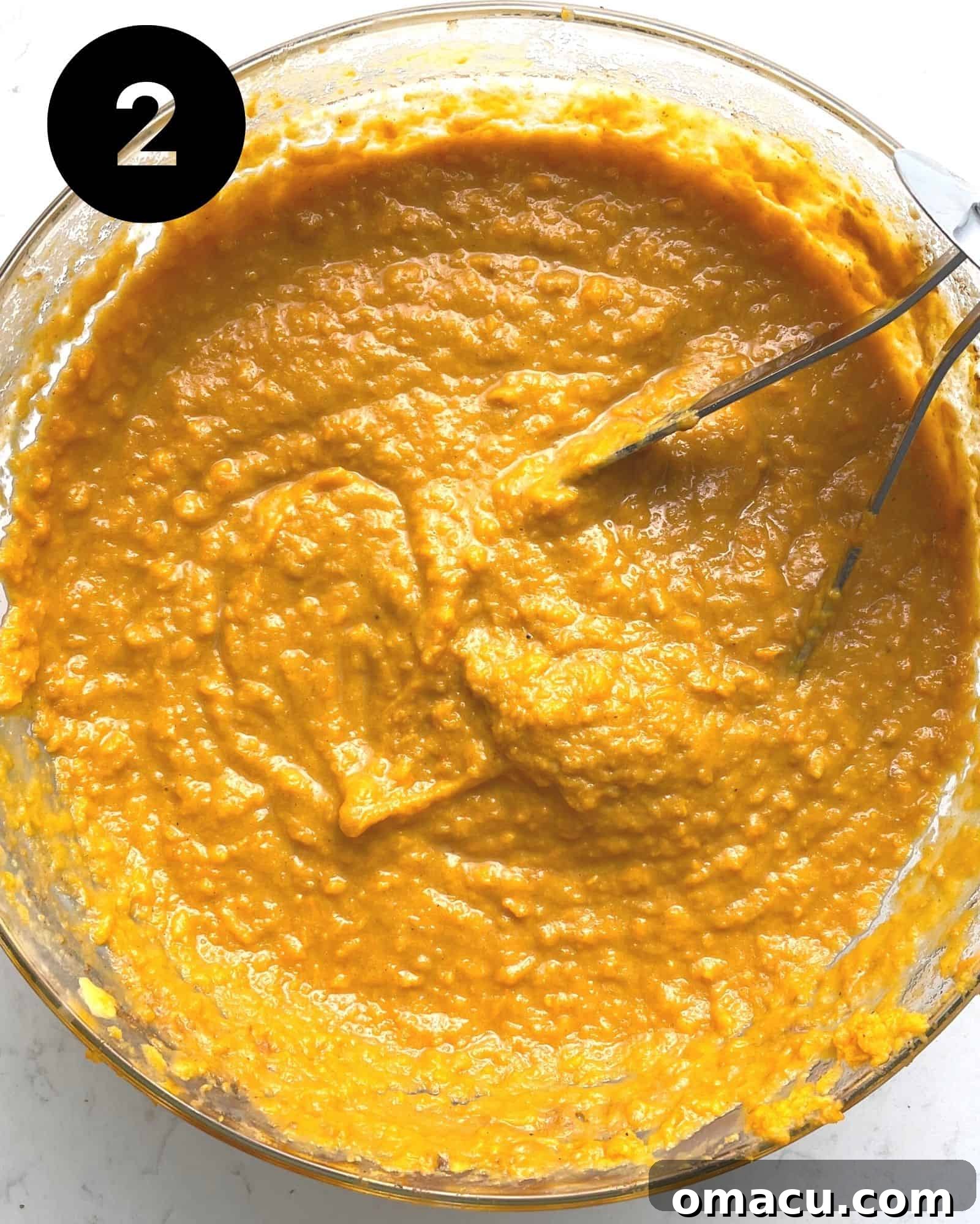 Close-up of smooth and creamy mashed sweet potatoes in a large mixing bowl, perfectly blended.