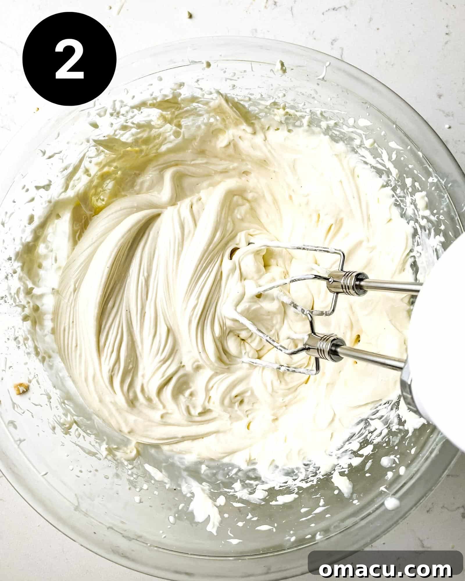 A creamy, fluffy no-bake cheesecake filling in a large mixing bowl, perfectly prepared.