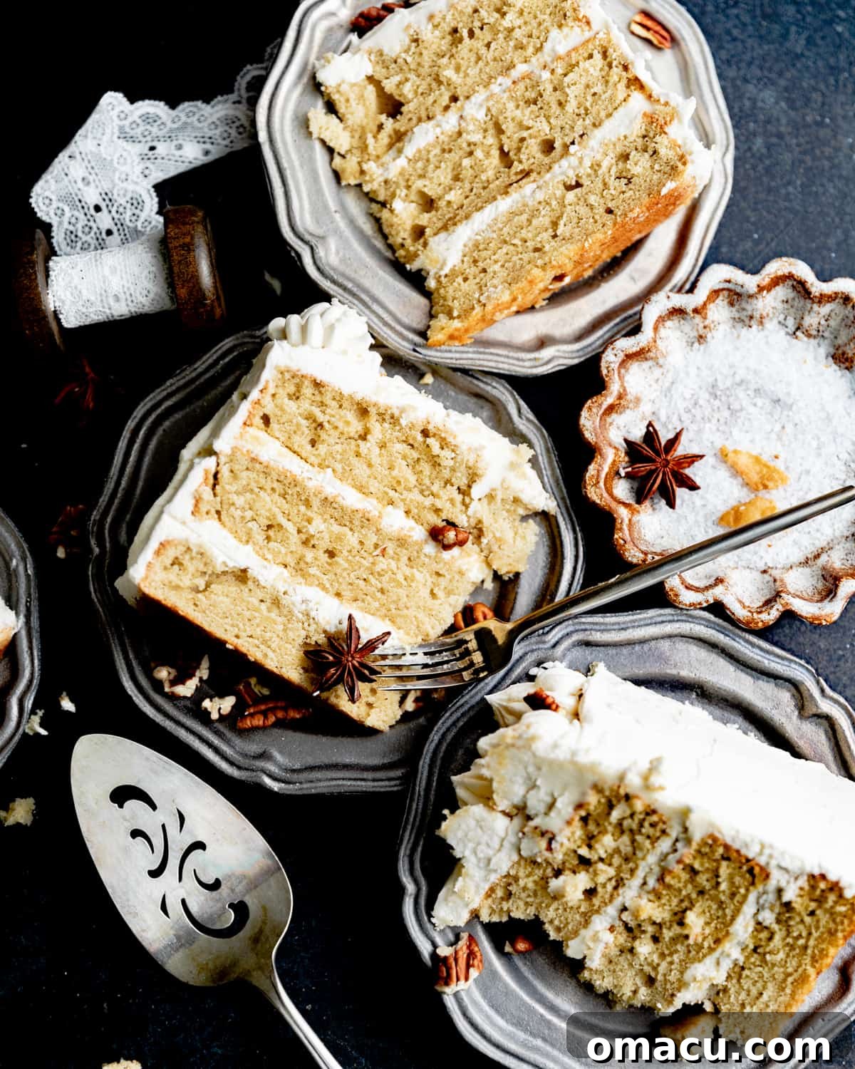 Close-up of three slices of cardamom cake, beautifully layered and frosted with maple buttercream, served on white plates.