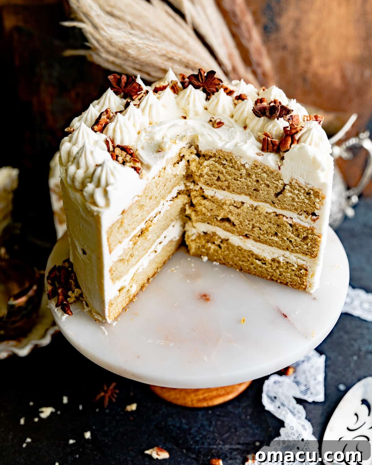A beautifully cut cardamom cake showing its distinct three layers of moist cake and creamy maple buttercream.