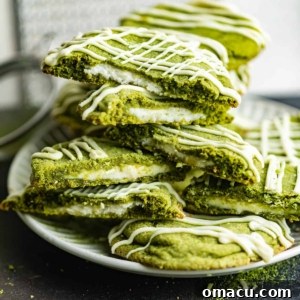 matcha cookies on a plate stacked on top of each other.