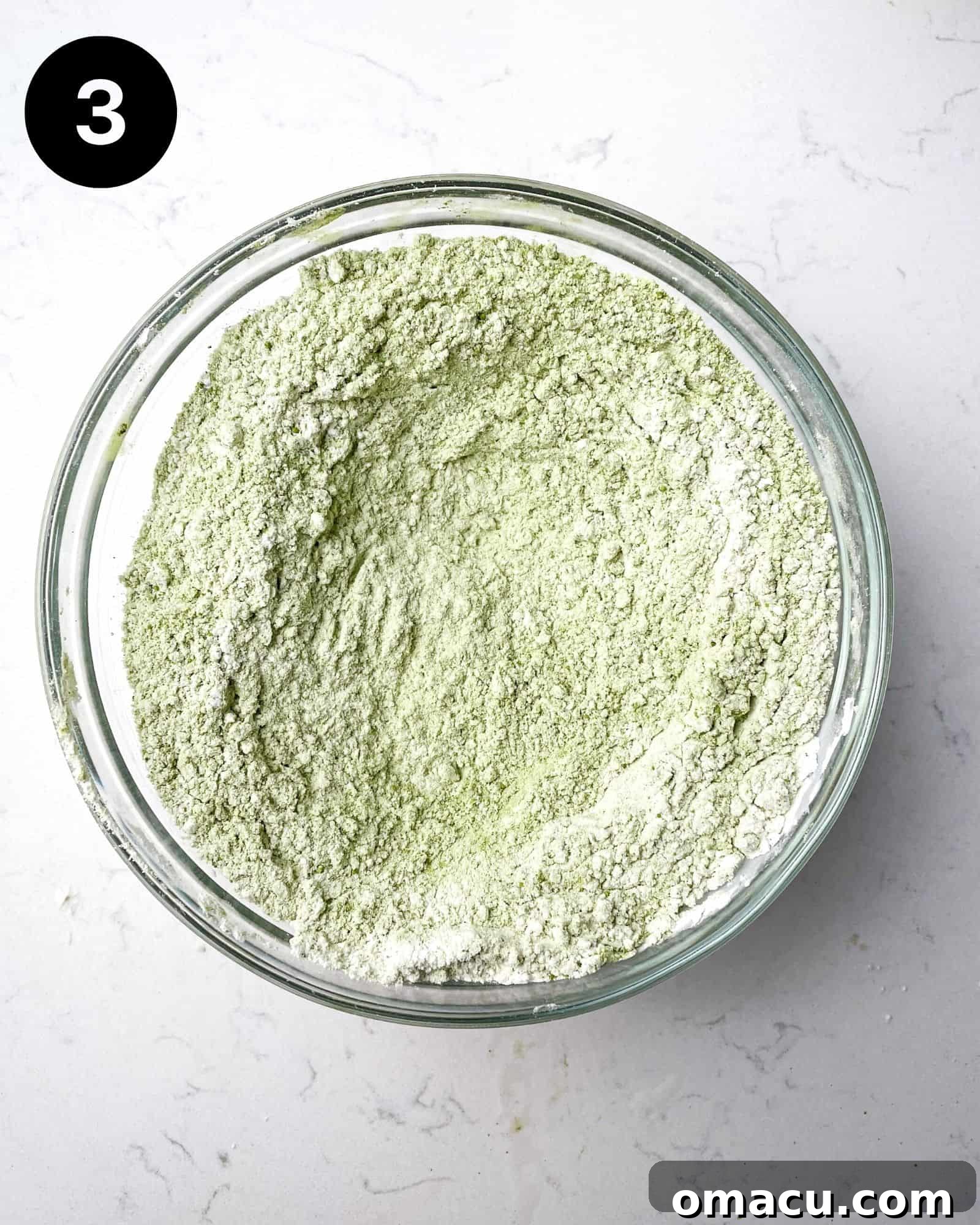 A bowl showcasing the vibrant green matcha powder mixed with flour and leavening agents, perfectly combined for the cookie dough.